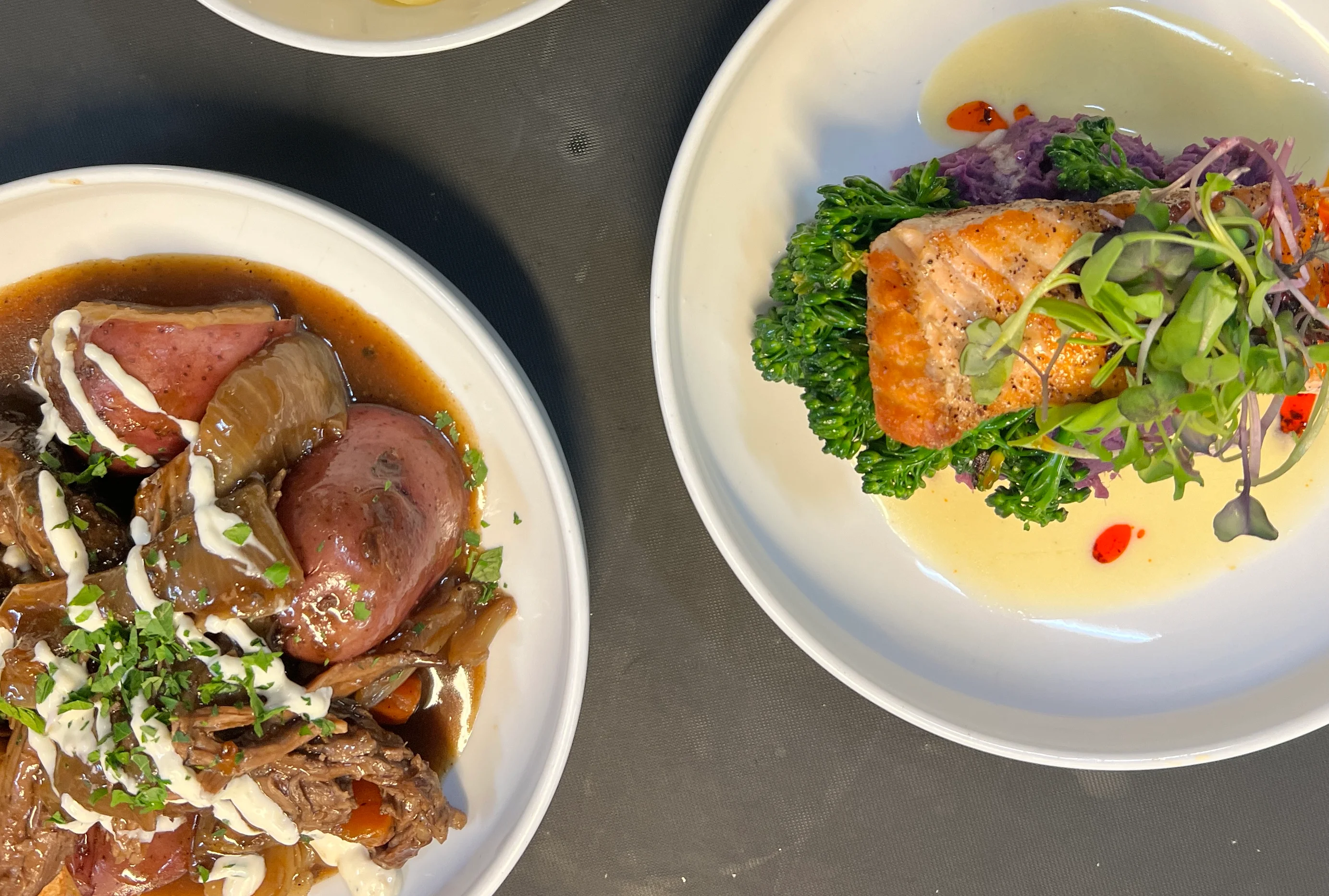 Grilled salmon with greens and sauce, served with macaroni and beef stew