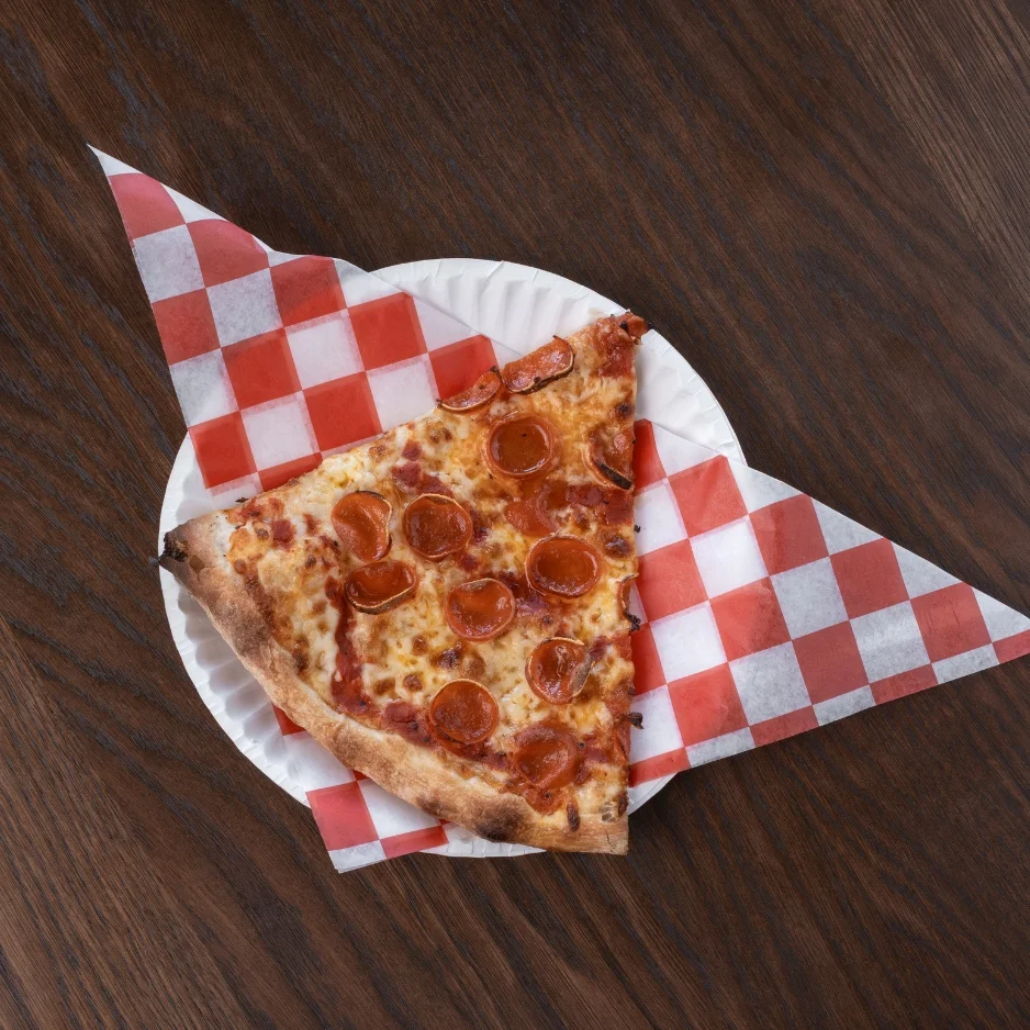 Slice of pepperoni pizza on a paper plate