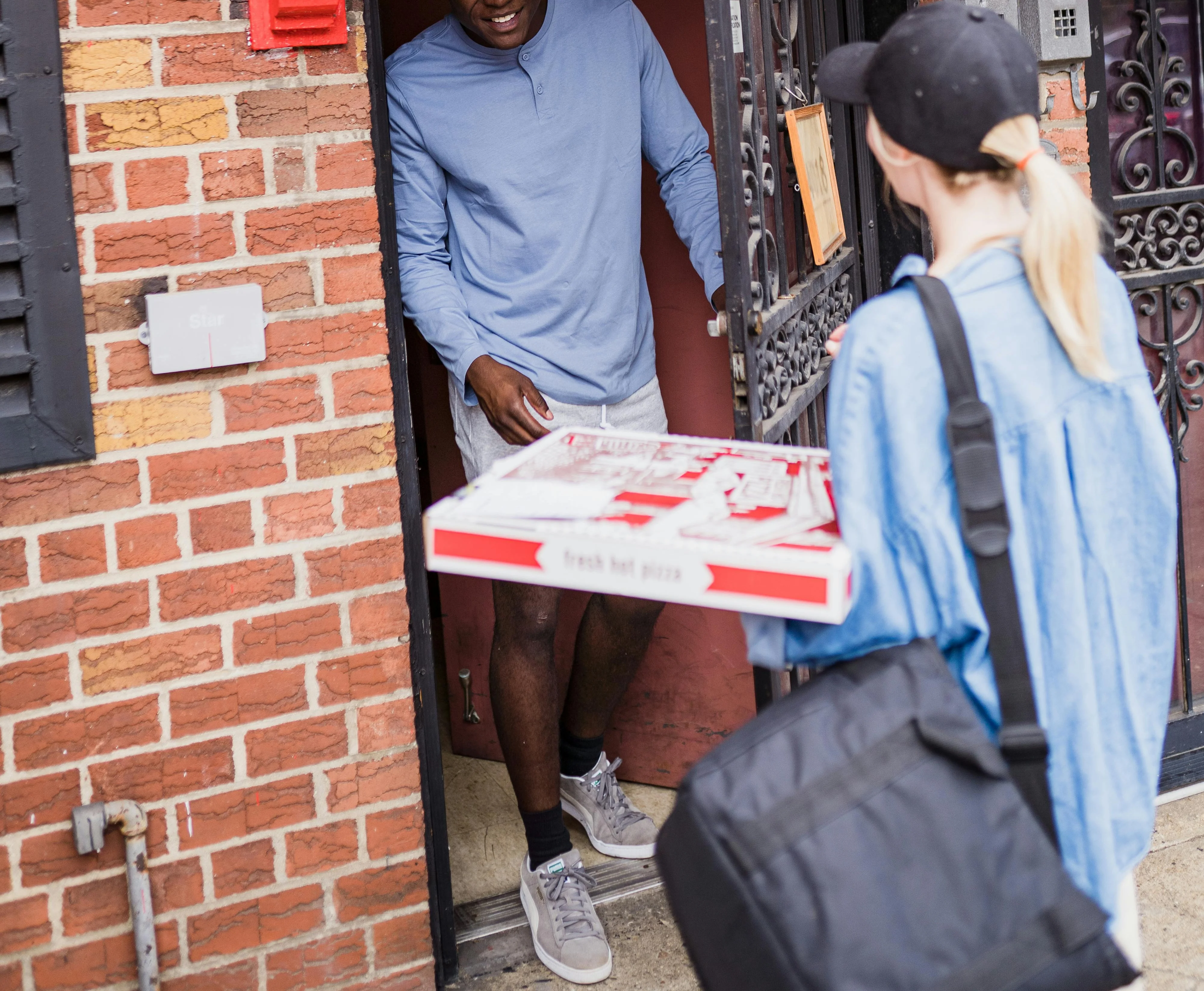 Pizza delivery at the door with a smiling customer