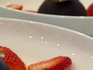 Elegant chocolate mousse dessert with strawberries and edible flowers