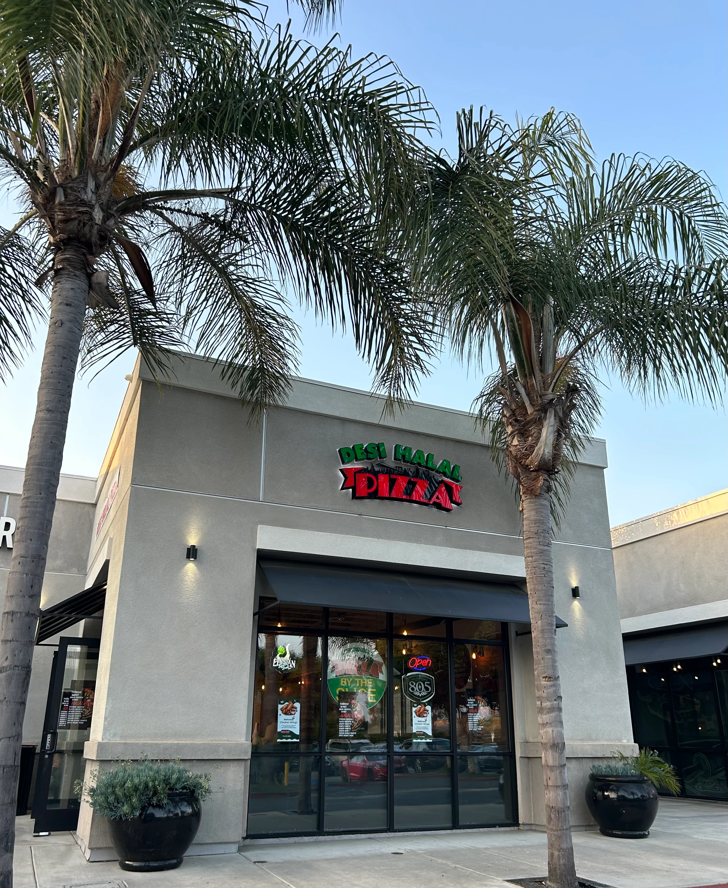 Exterior view of Desi Halal Pizza restaurant with palm trees