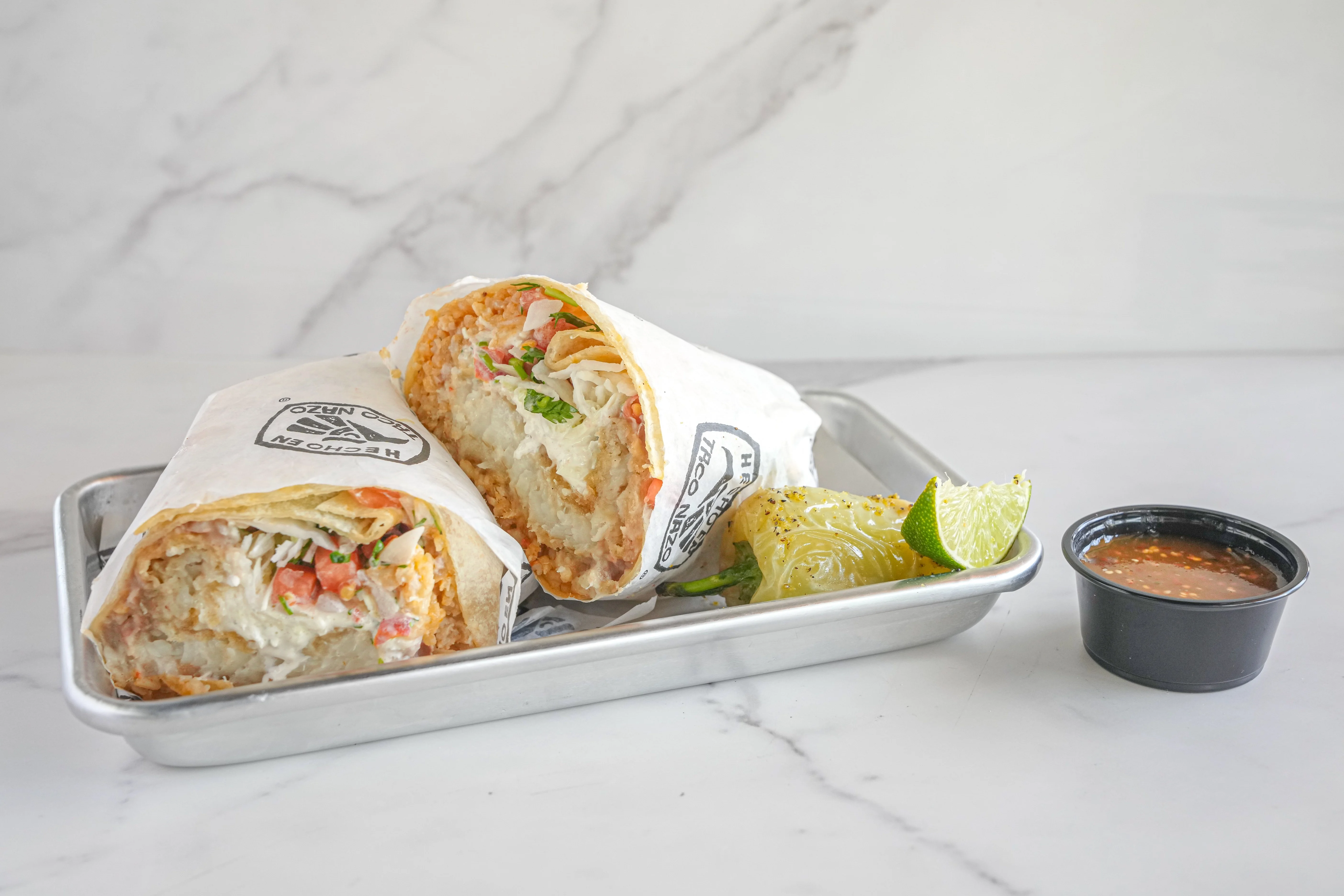 Plated Fish burrito with a chile, lime, and salsa