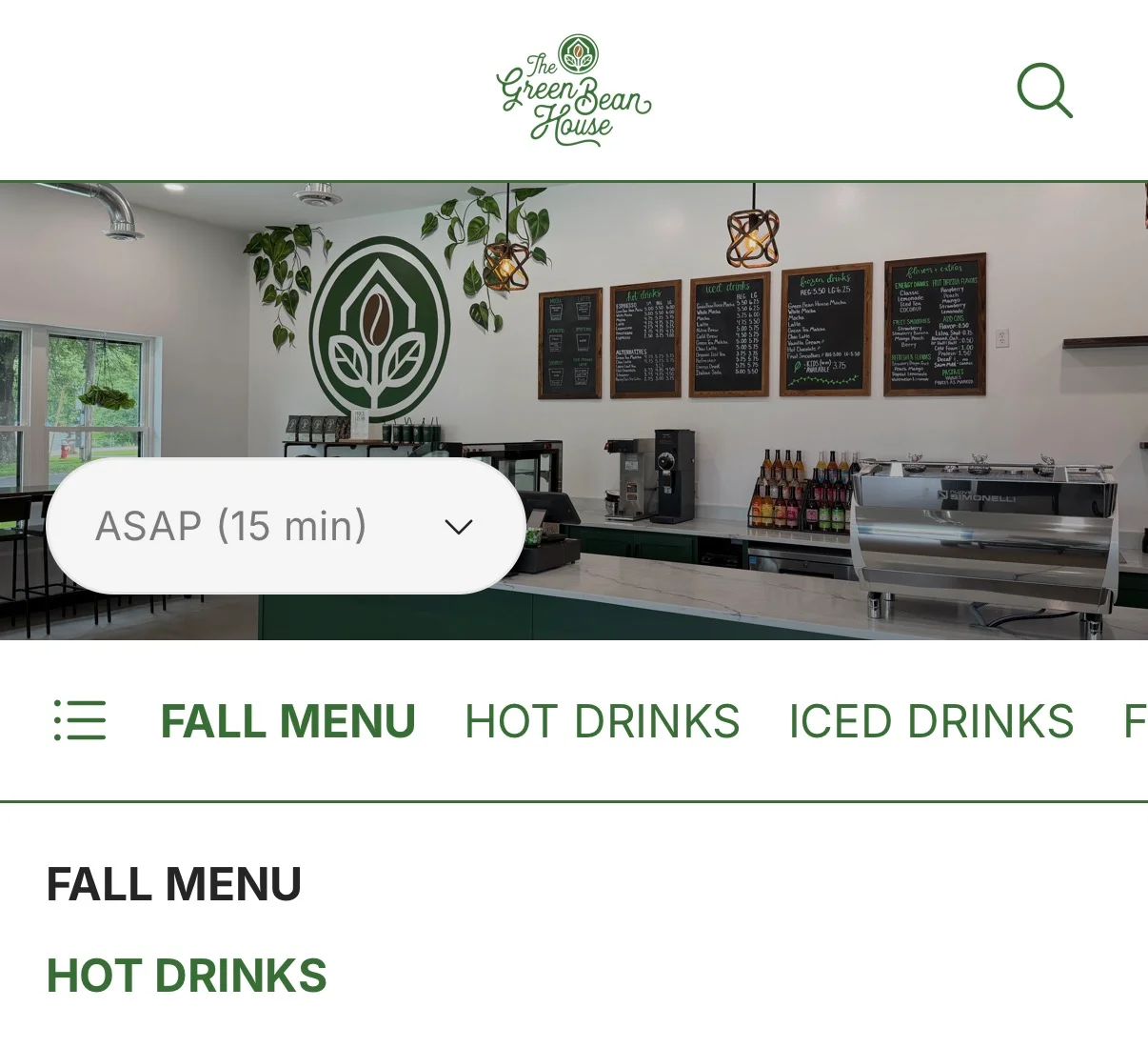Cozy café interior with green accents and a chalkboard menu