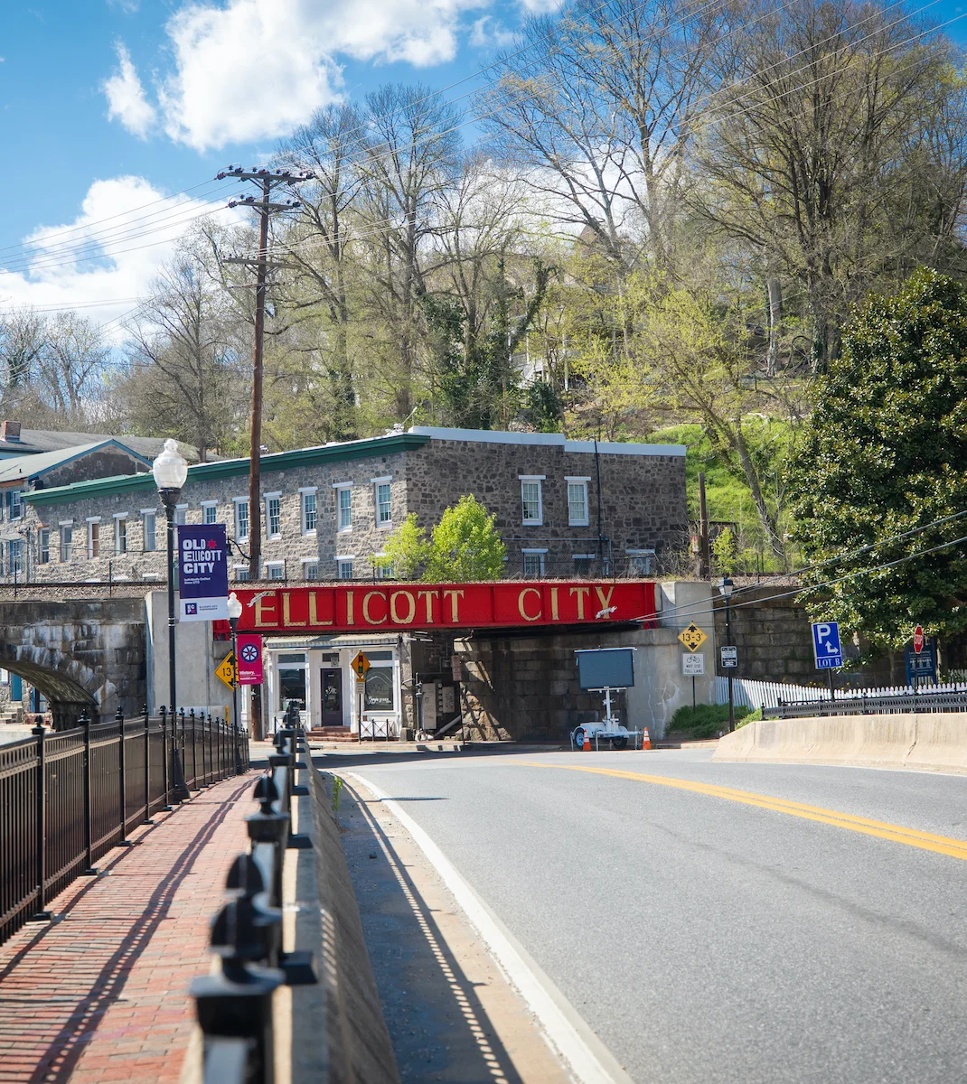 Historic Ellicott City entrance with stone bridge and vibrant signage