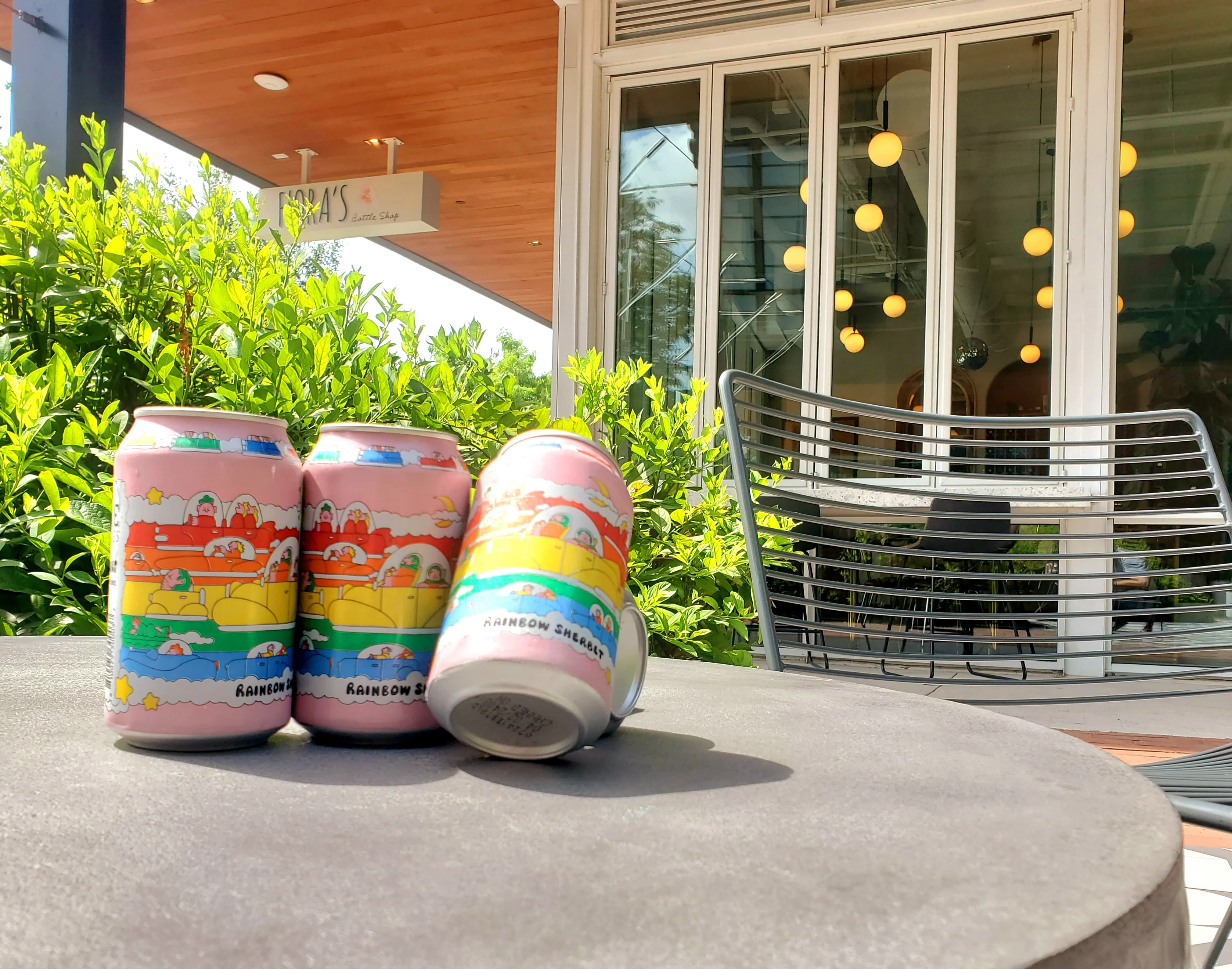 Colorful cans of craft beer on a table outside a cafe