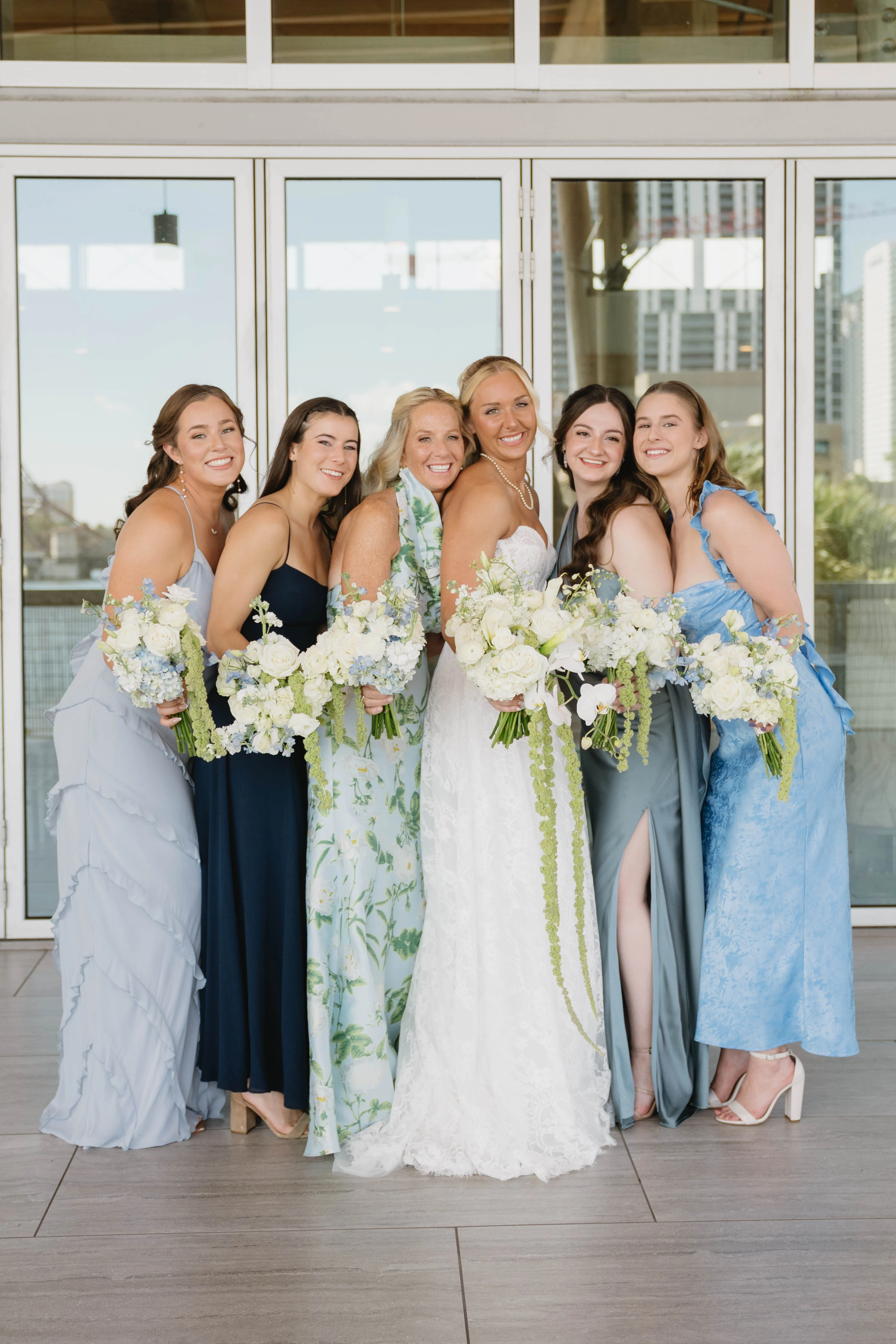 Bridal party posing with bouquets in elegant dresses