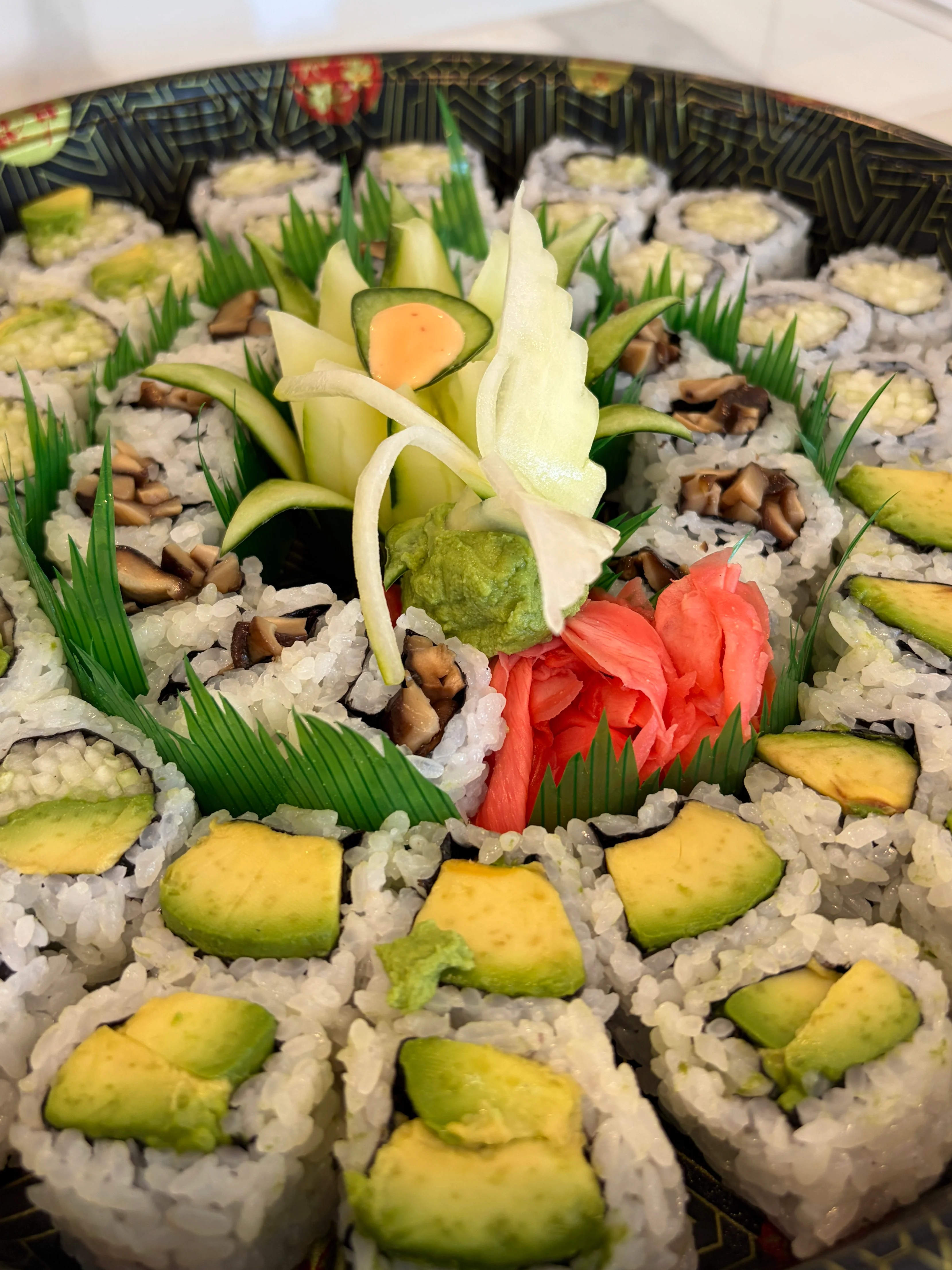 Artfully arranged sushi platter with avocado and decorative garnishes