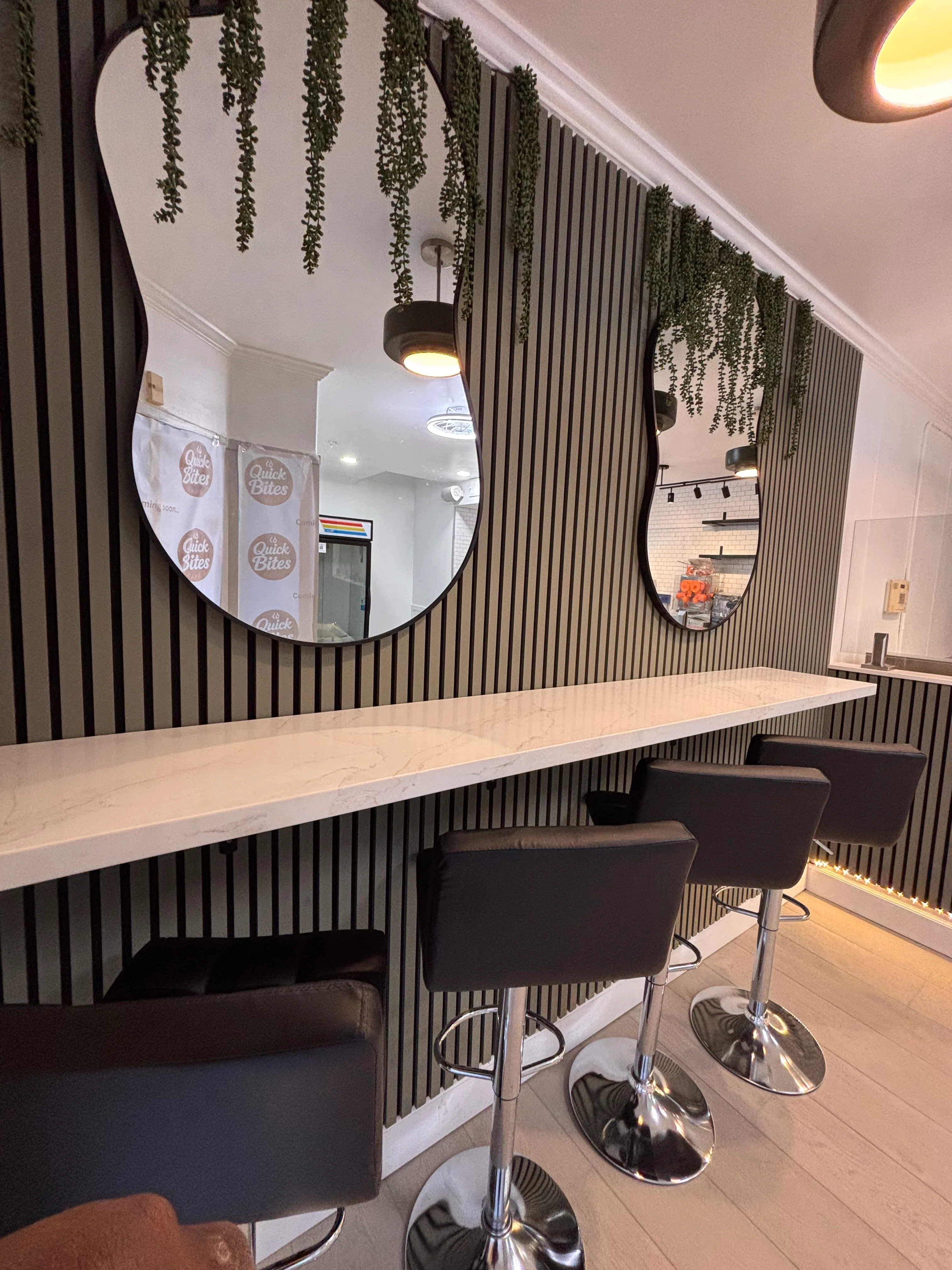 Modern restaurant interior with stylish bar seating and decorative mirrors