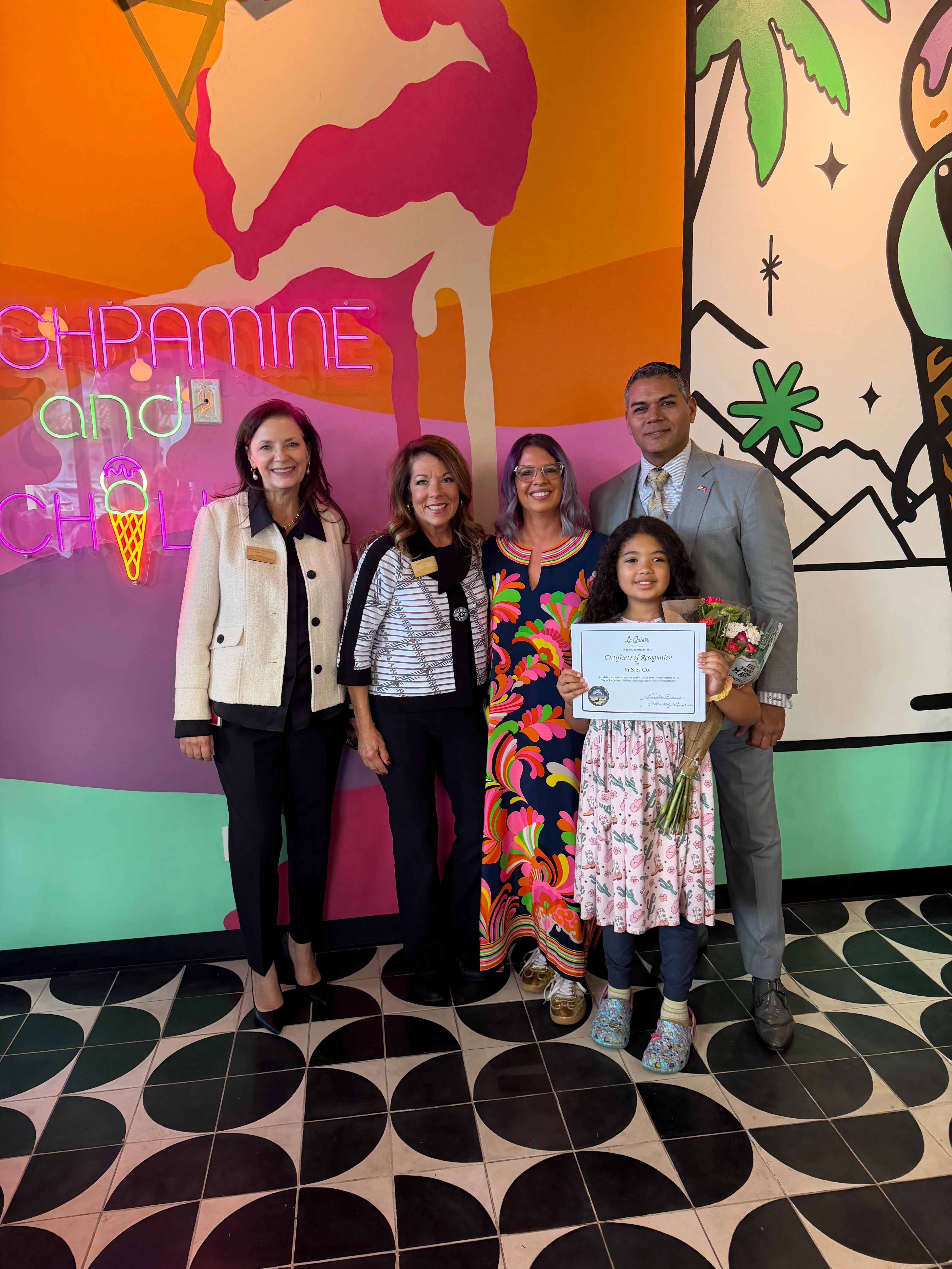 Celebration at a vibrant ice cream shop with a colorful mural
