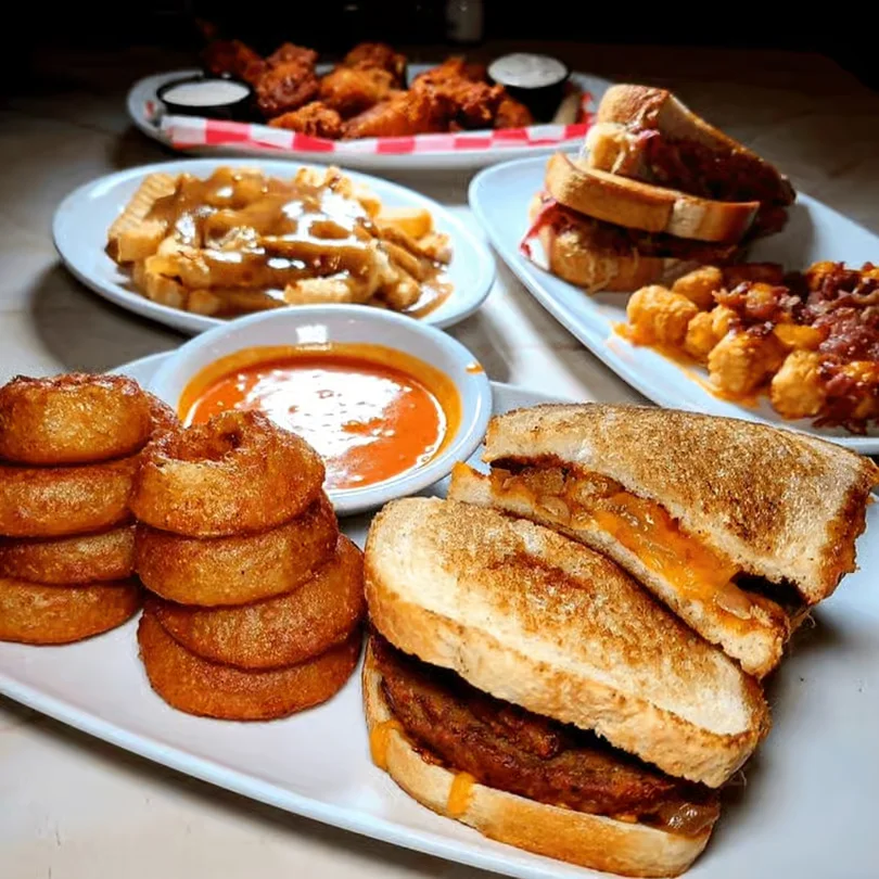 Moonlite Diner comfort food spread featuring grilled sandwiches, crispy onion rings, loaded fries, chicken wings, and classic diner favorites.