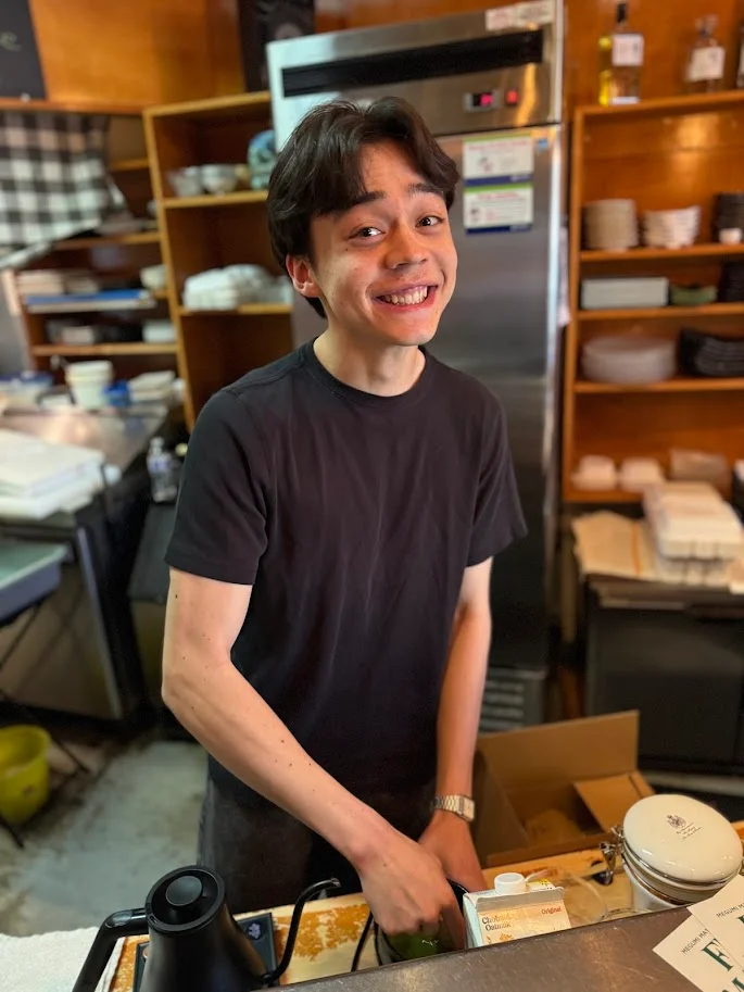 Friendly staff member at a cozy restaurant counter