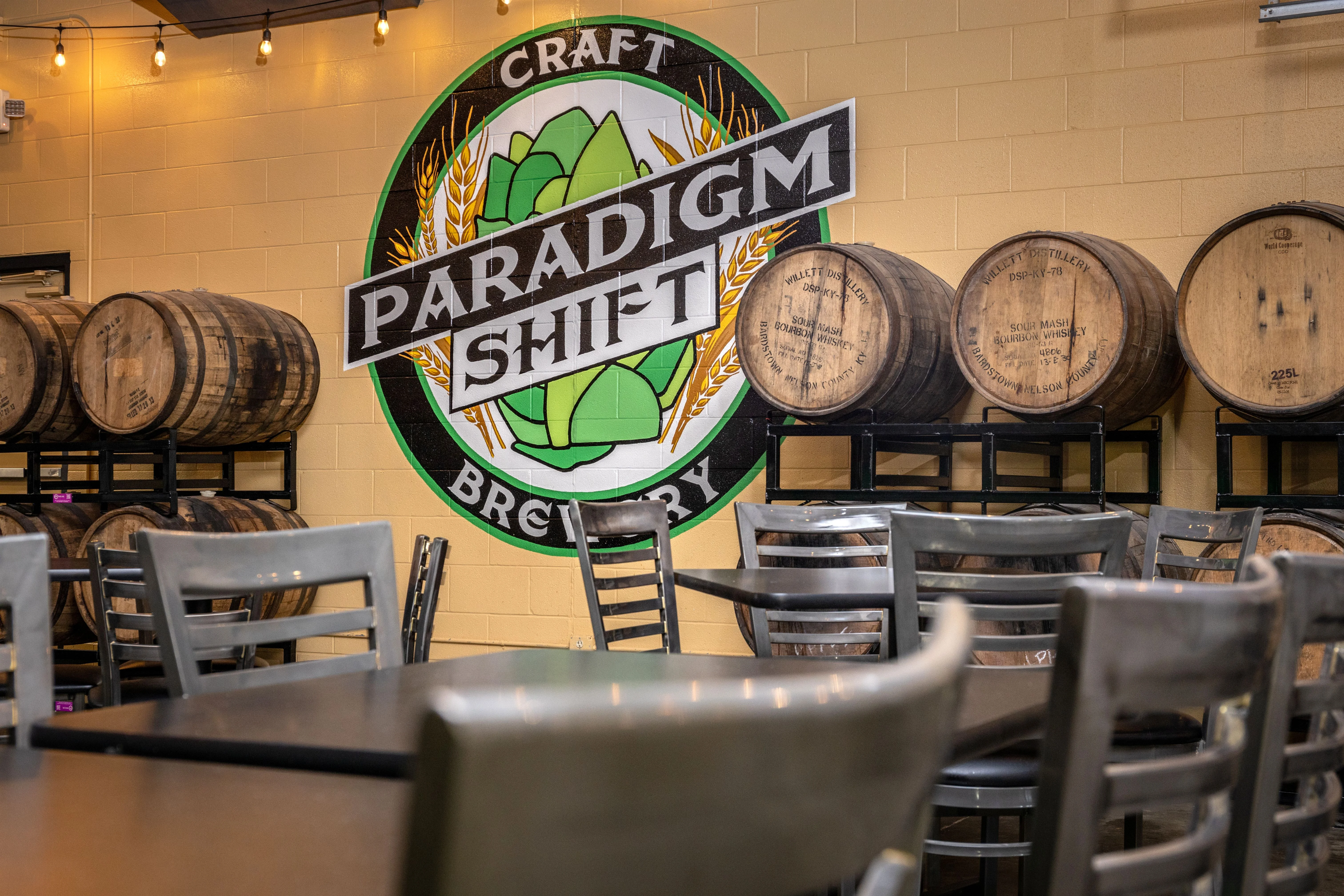 Craft brewery interior with barrels and mural