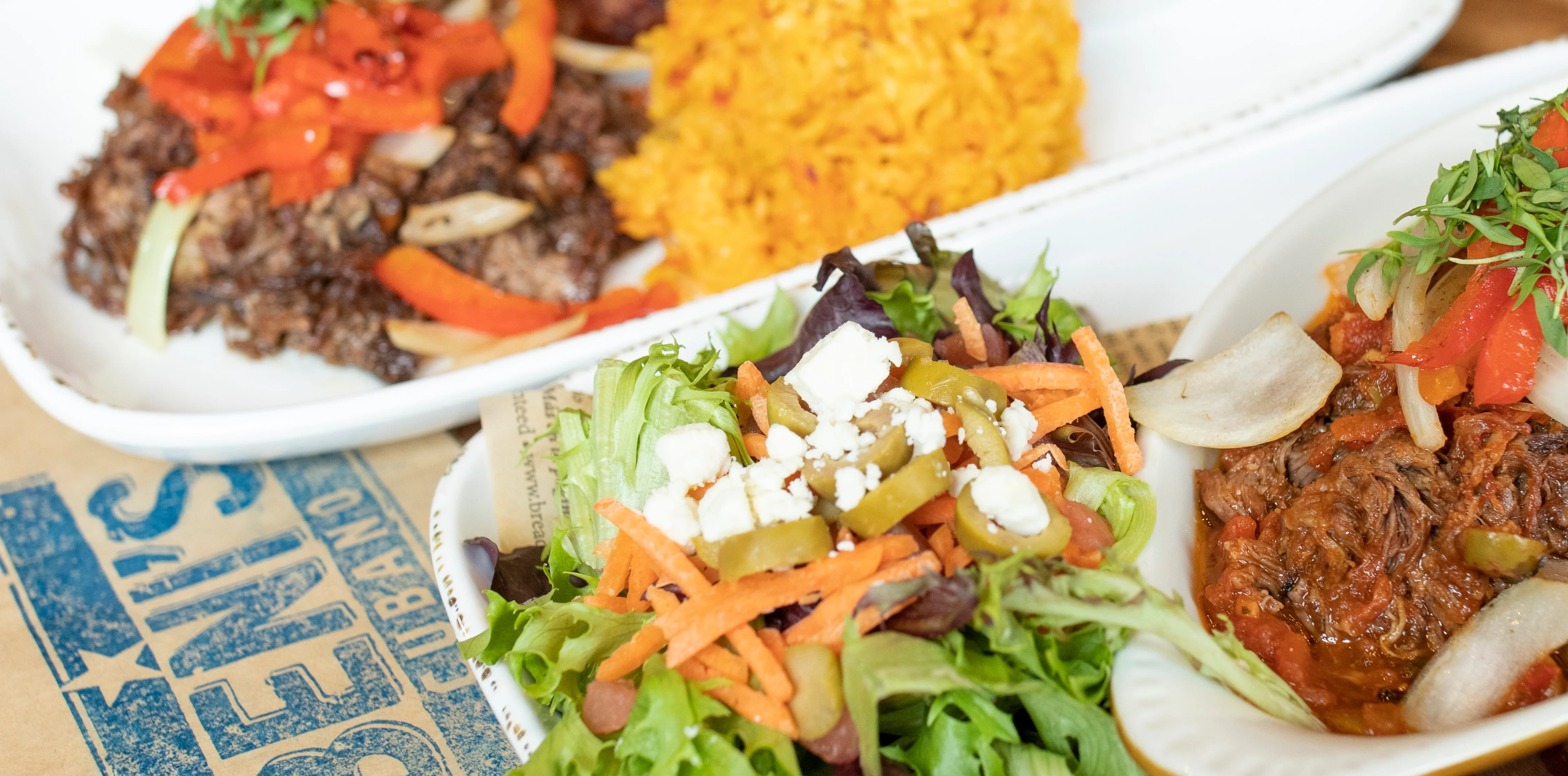 Cuban ropa vieja served with yellow rice and fresh salad