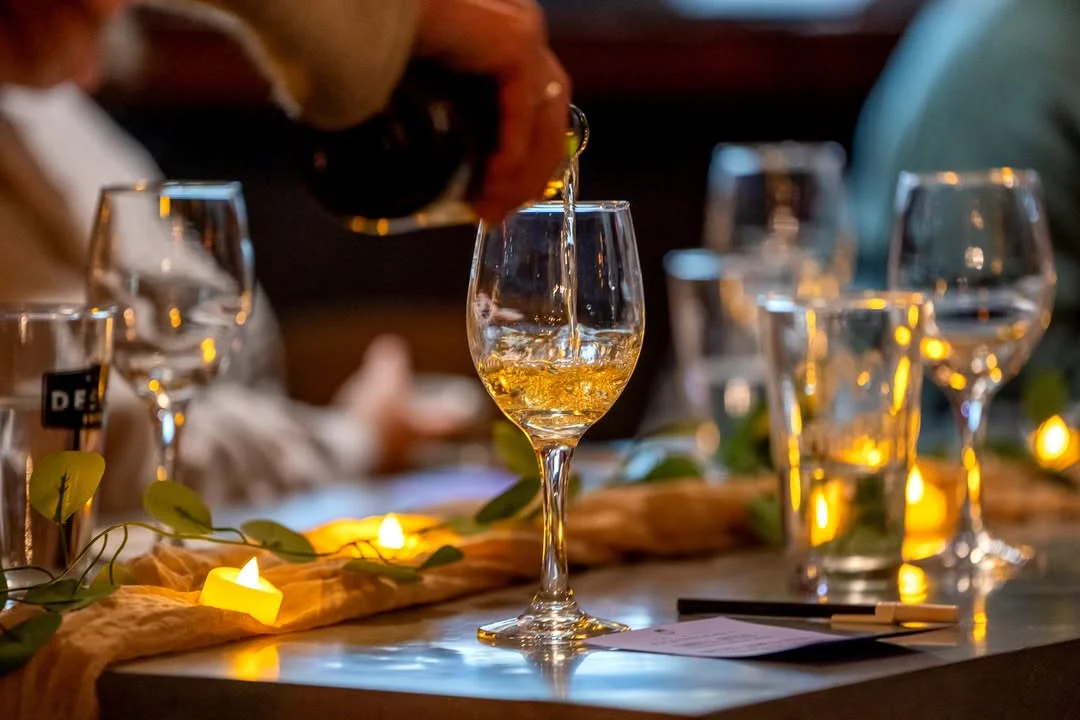 Bartender pouring wine into a glass at a cozy restaurant setting