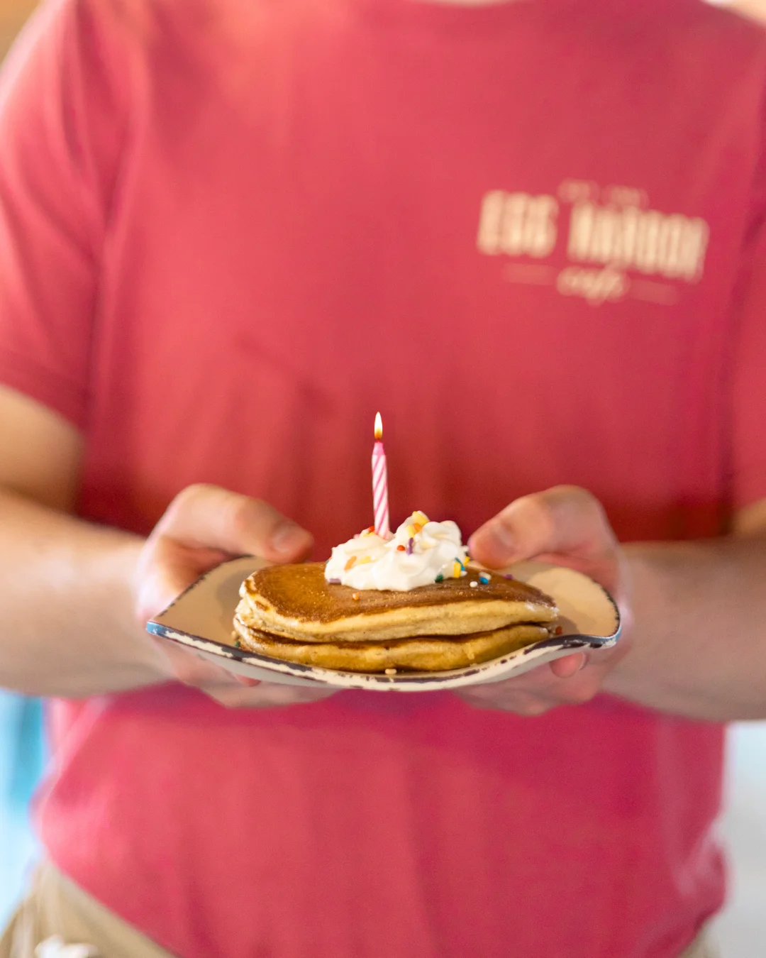 Birthday pancakes with a candle and whipped cream