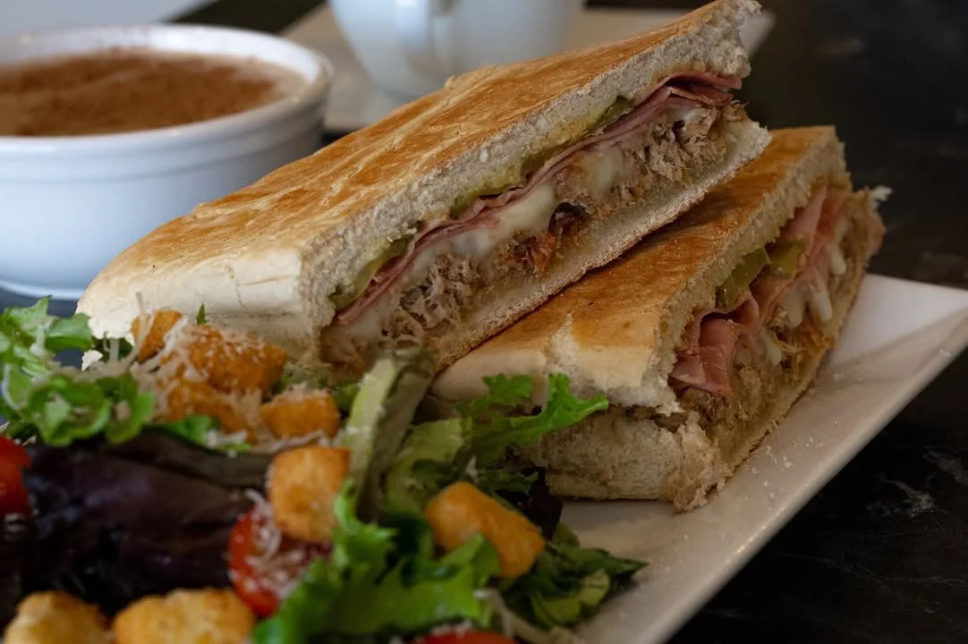 Cuban sandwich with ham and pickles served with a side salad