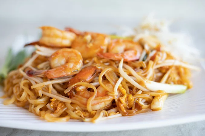 Shrimp pad thai served with bean sprouts and lime