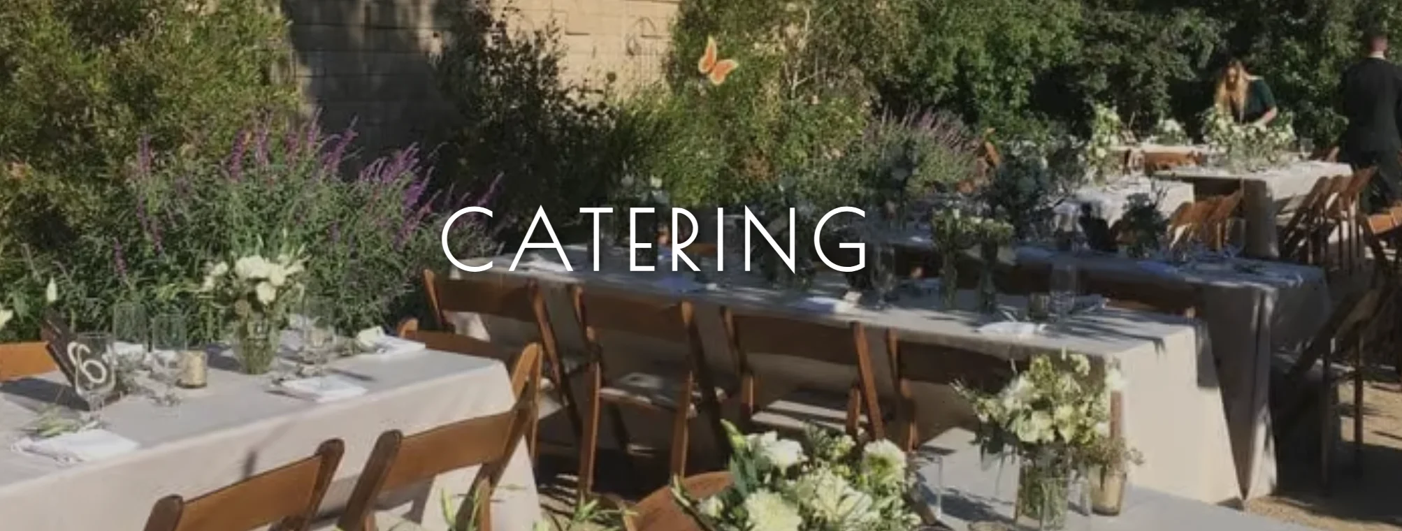 Elegant outdoor catering setup with floral arrangements