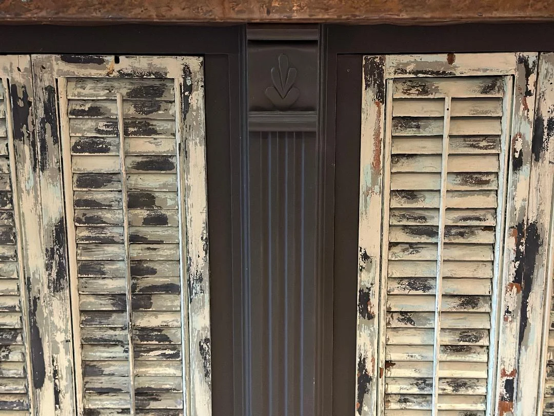 Vintage wooden shutters with peeling paint in a rustic setting