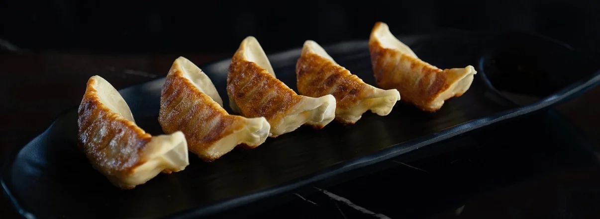 Japanese gyoza dumplings arranged on a black plate