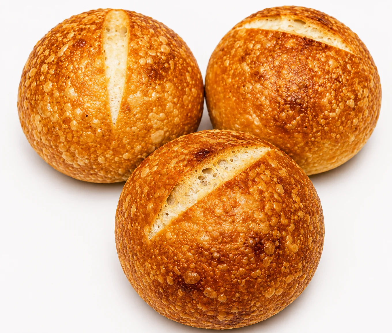 Three golden, crusty bread rolls with slits on top.