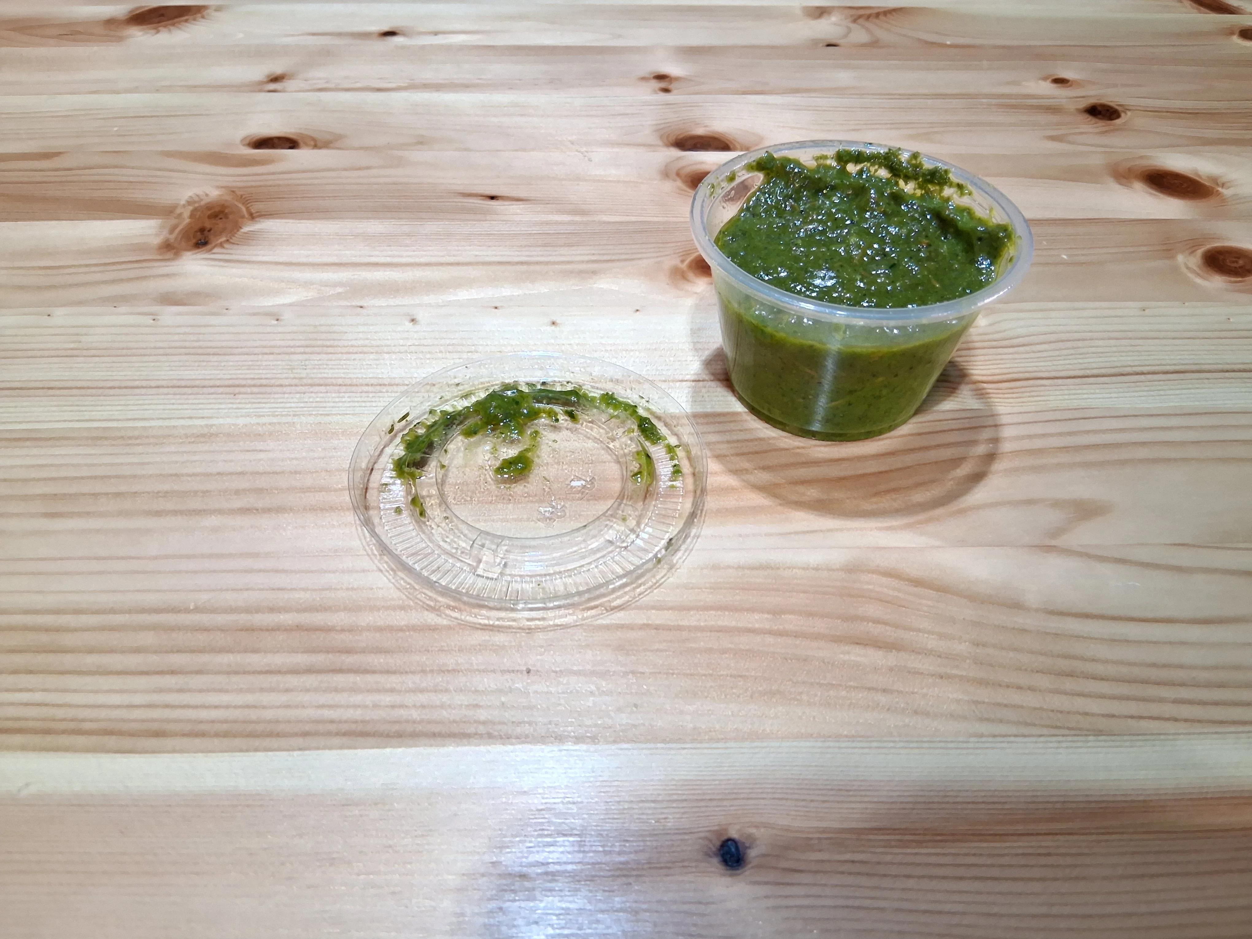 Fresh green chutney in a plastic container