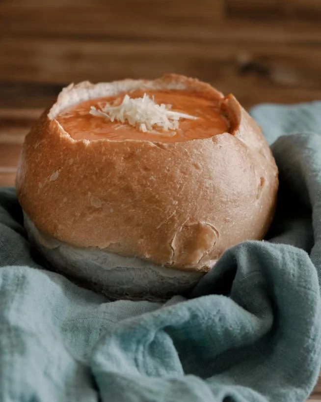 Bread bowl filled with creamy tomato soup