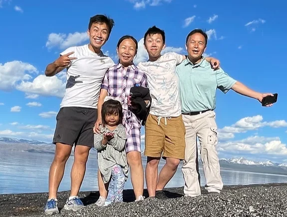 Family posing together outdoors with scenic backdrop