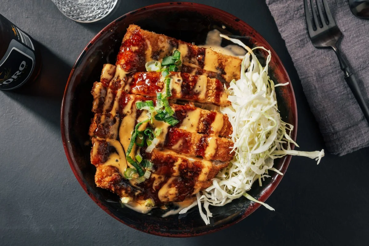 A delicious crispy chicken donburi served in a bowl with toppings.