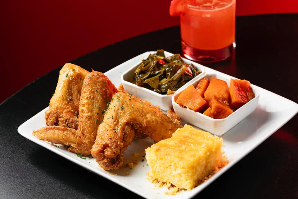 Southern fried chicken wings with sides of collard greens and cornbread