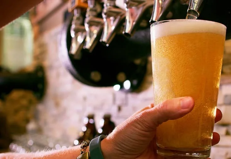 Bartender pouring a cold beer from a tap