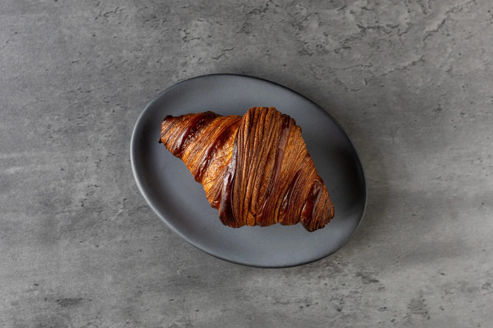 Golden-brown croissant on a sleek plate