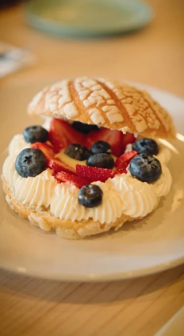 Japanese melon bread dessert with cream and berries
