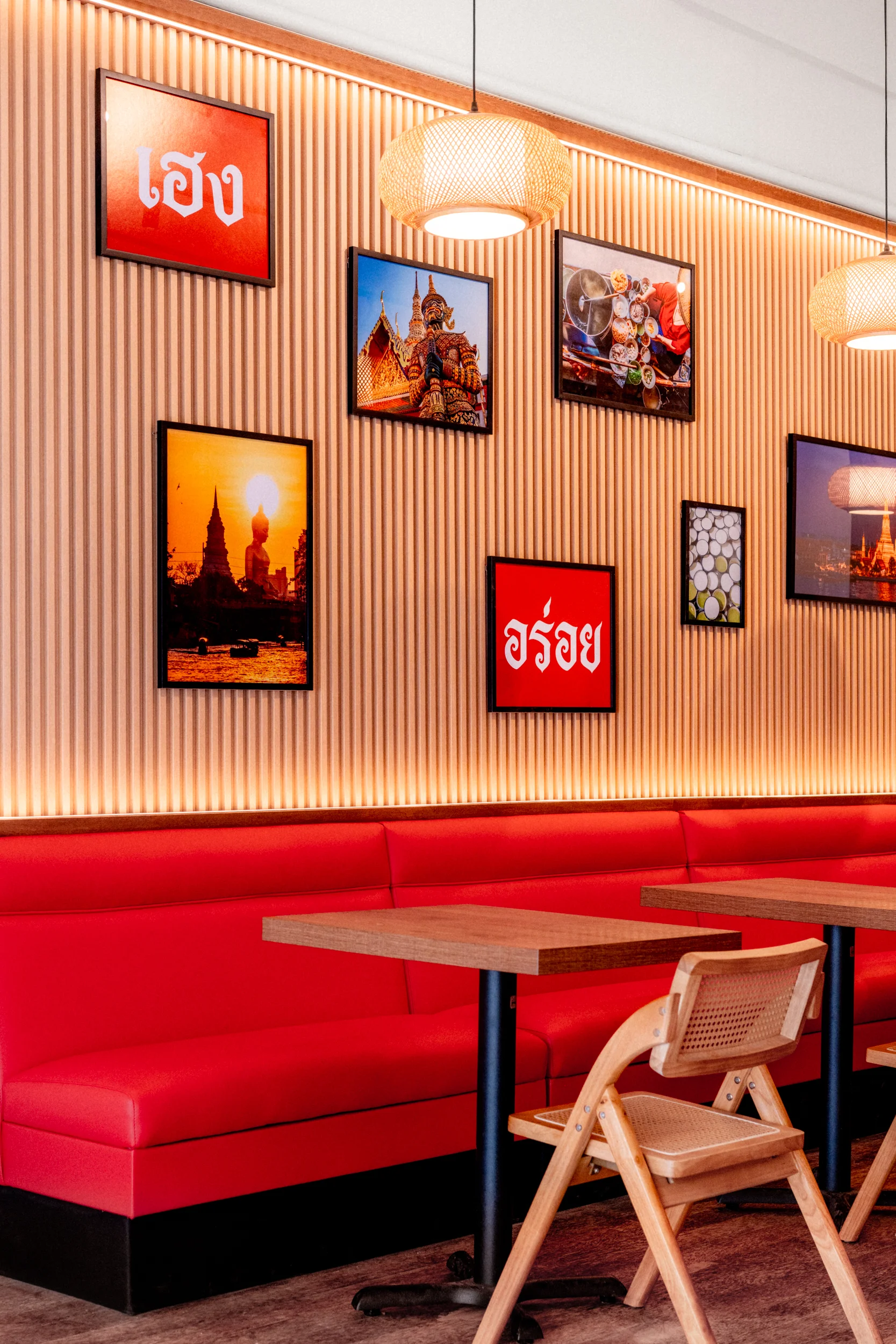 Modern restaurant interior with red seating and cultural artwork