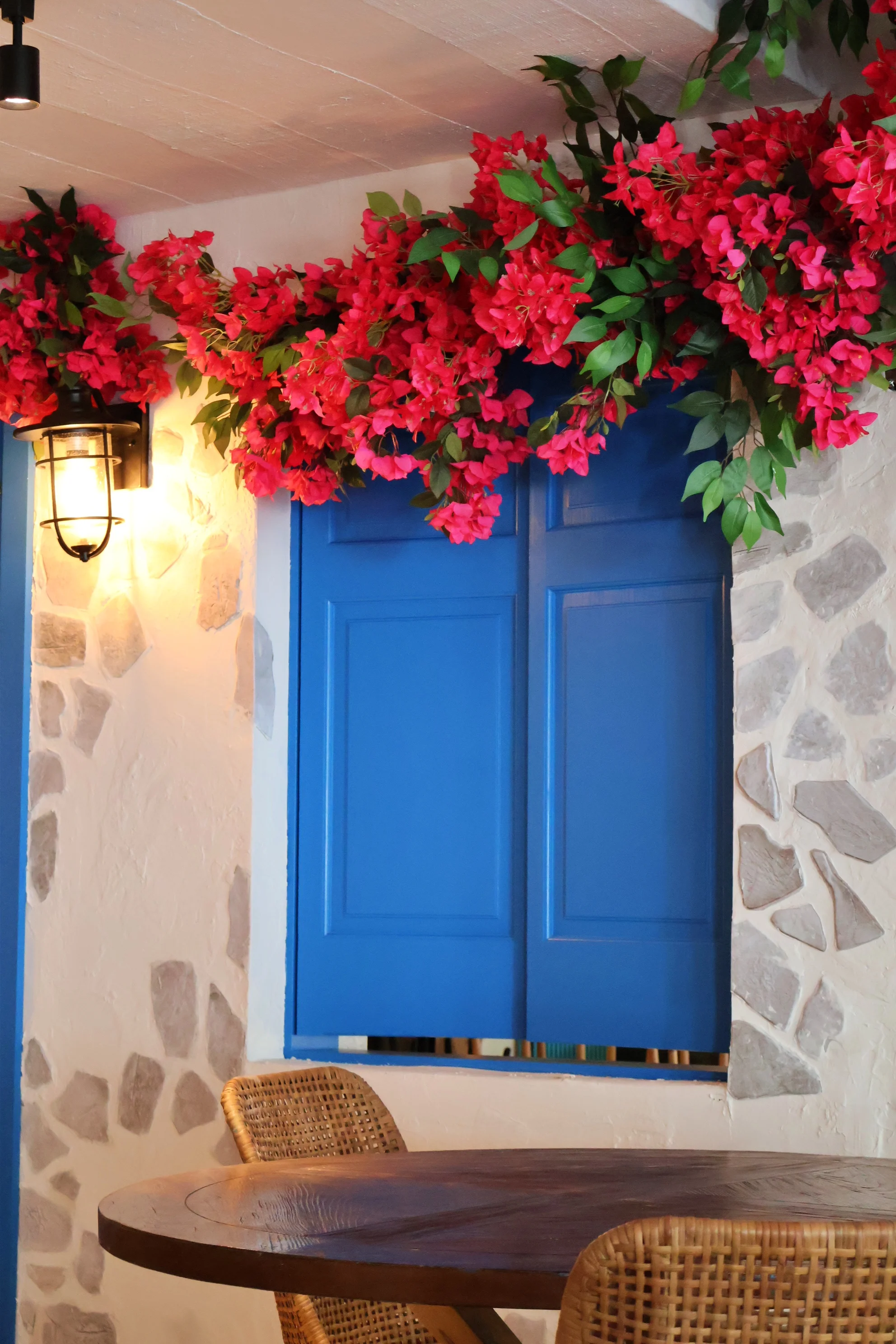 Charming restaurant interior with blue shutters and vibrant flowers