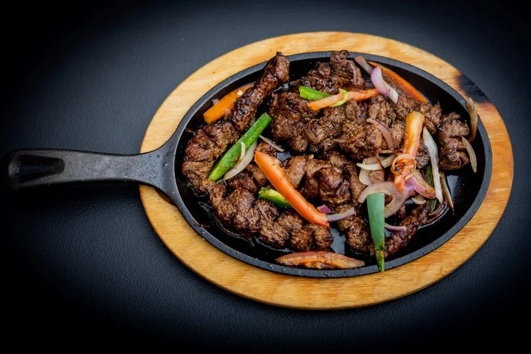 Sizzling beef fajitas served on a hot skillet