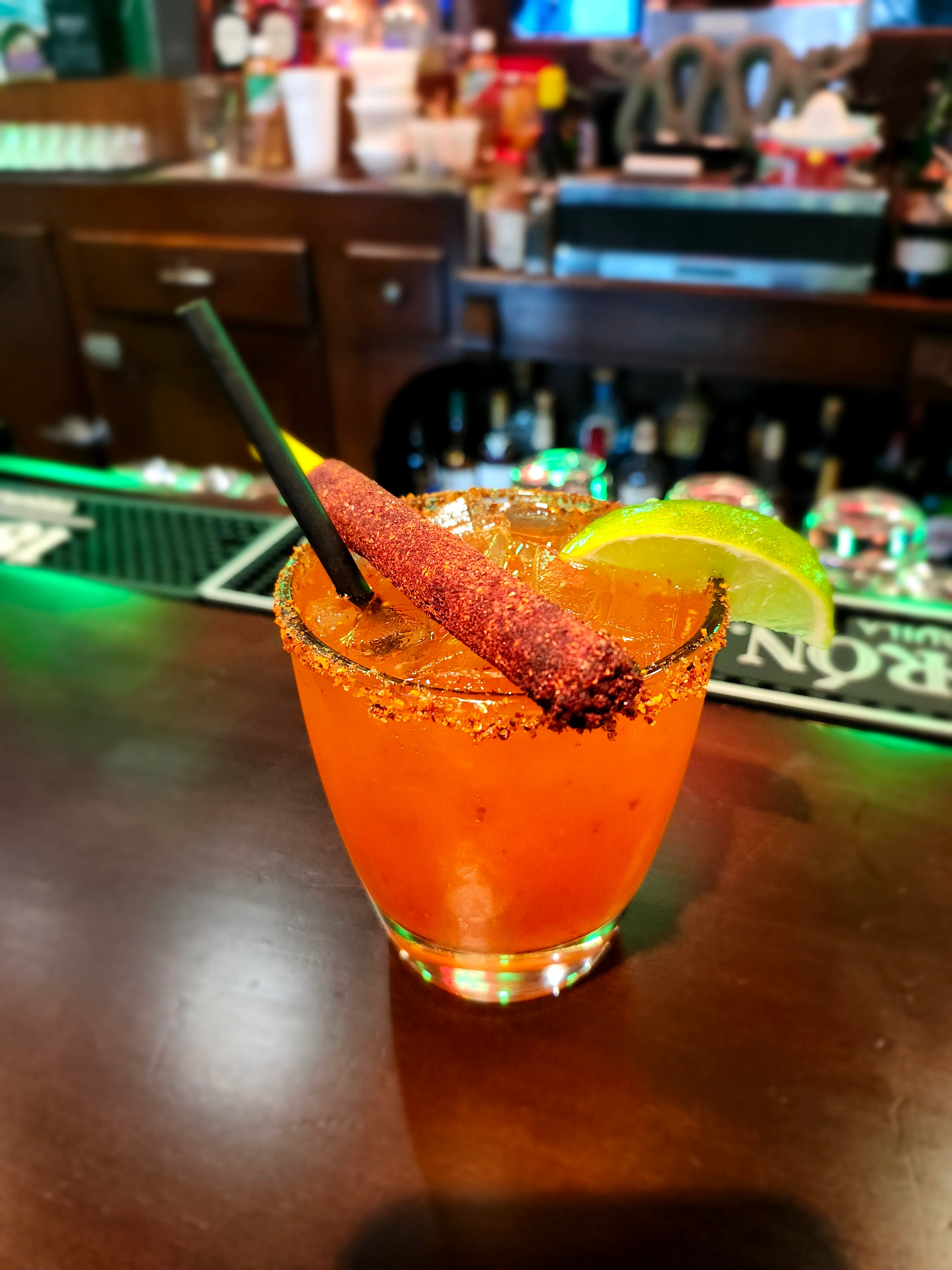 Colorful Mexican cocktail with chili rim and lime garnish