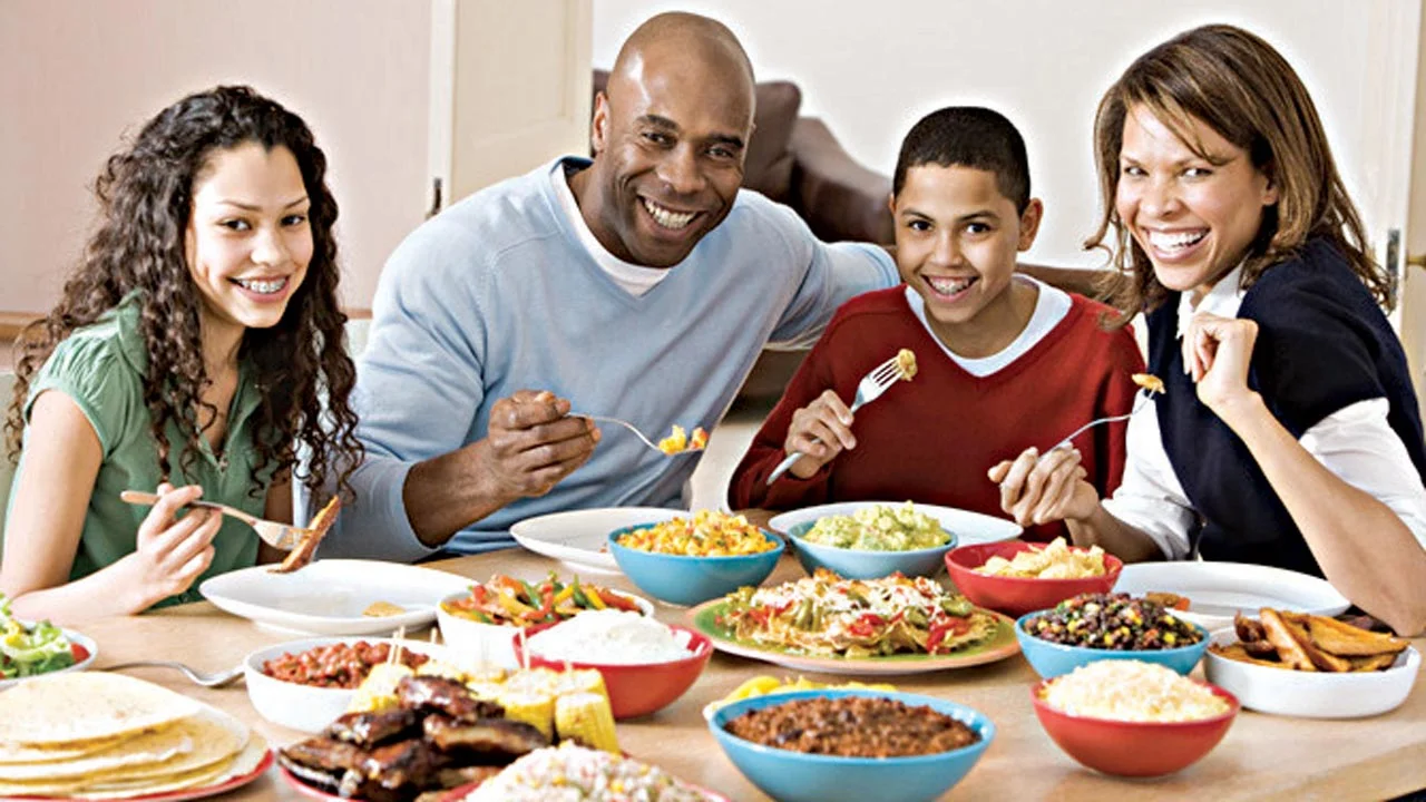 Family enjoying a festive Mexican meal with tacos and sides