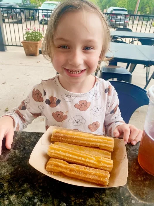 Child enjoying churros at a casual dining spot