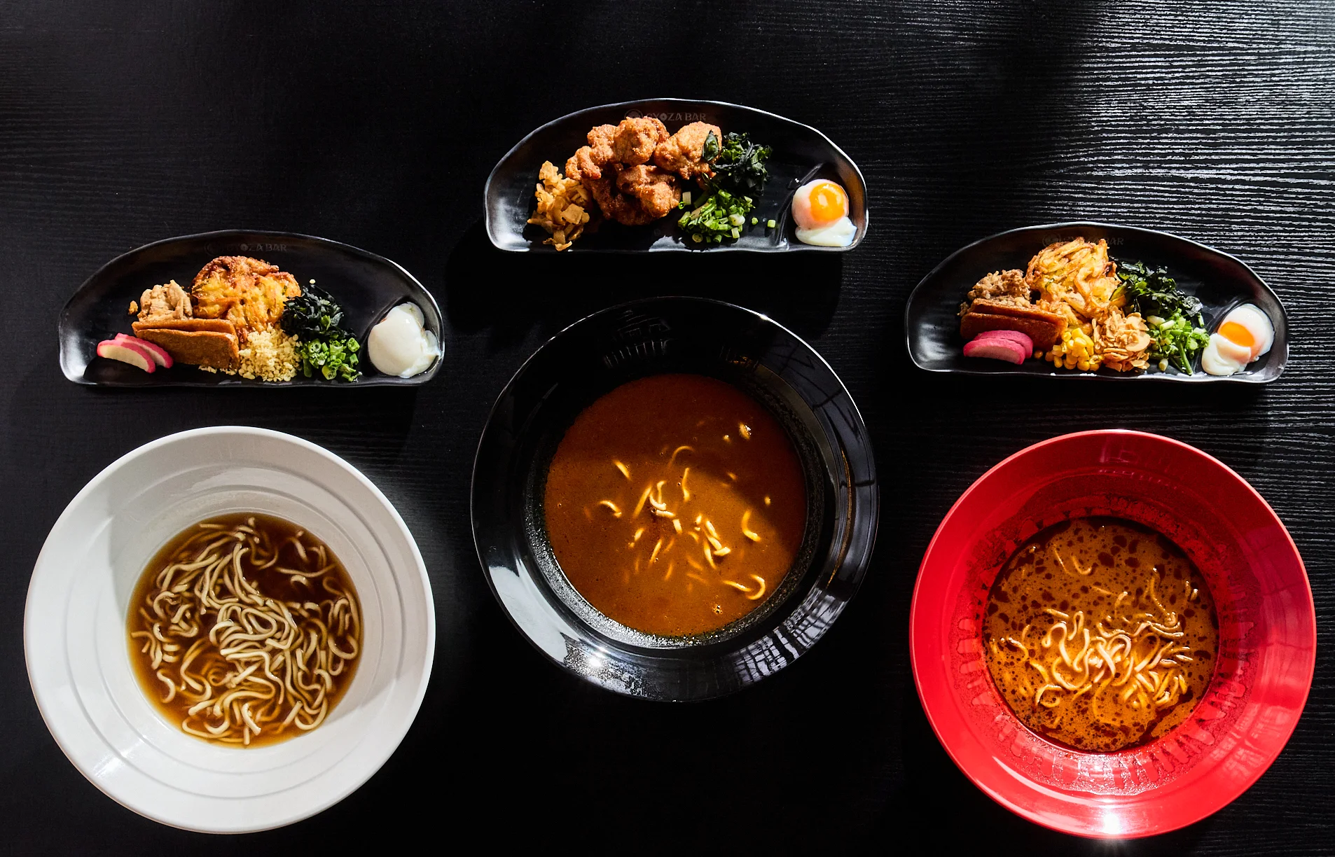 Japanese ramen bowls with assorted toppings and sides