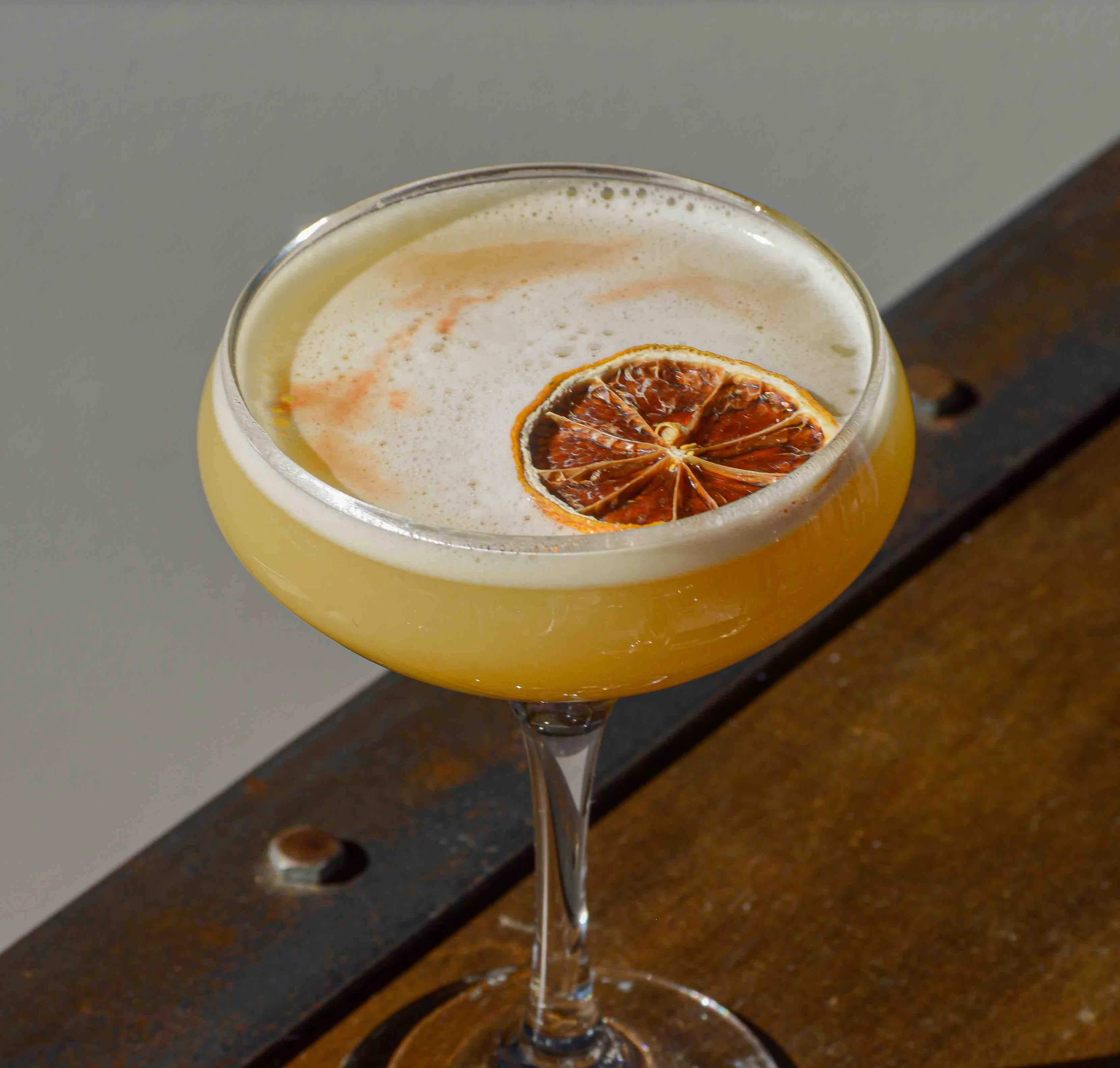 Pineapple Sour cocktail on a wooden table