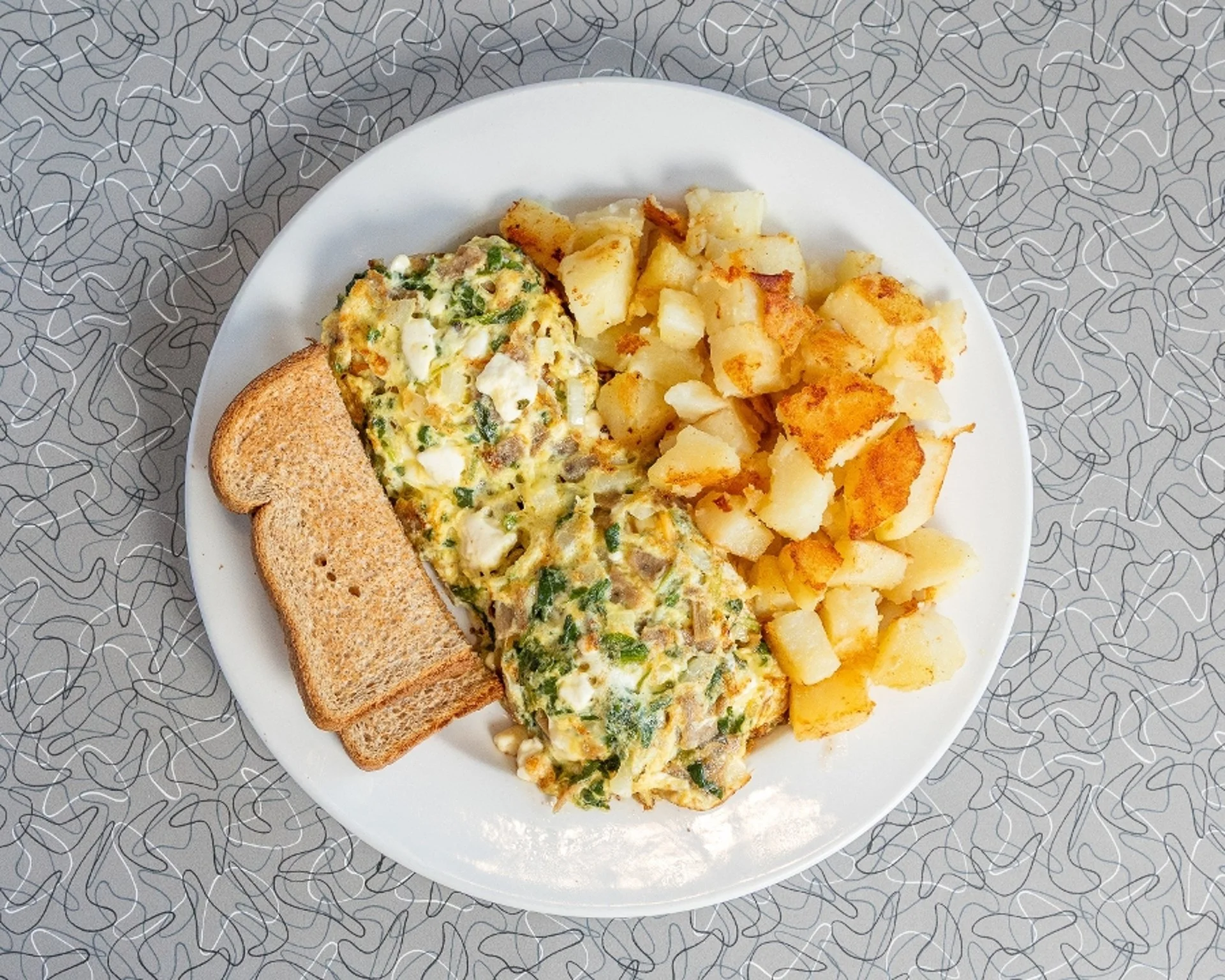 Scrambled eggs with breakfast sausage and home fries.