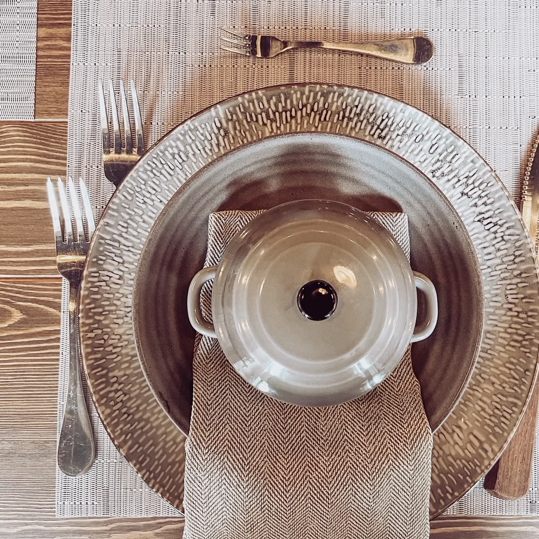 Elegant table setting with textured plates and a serving dish