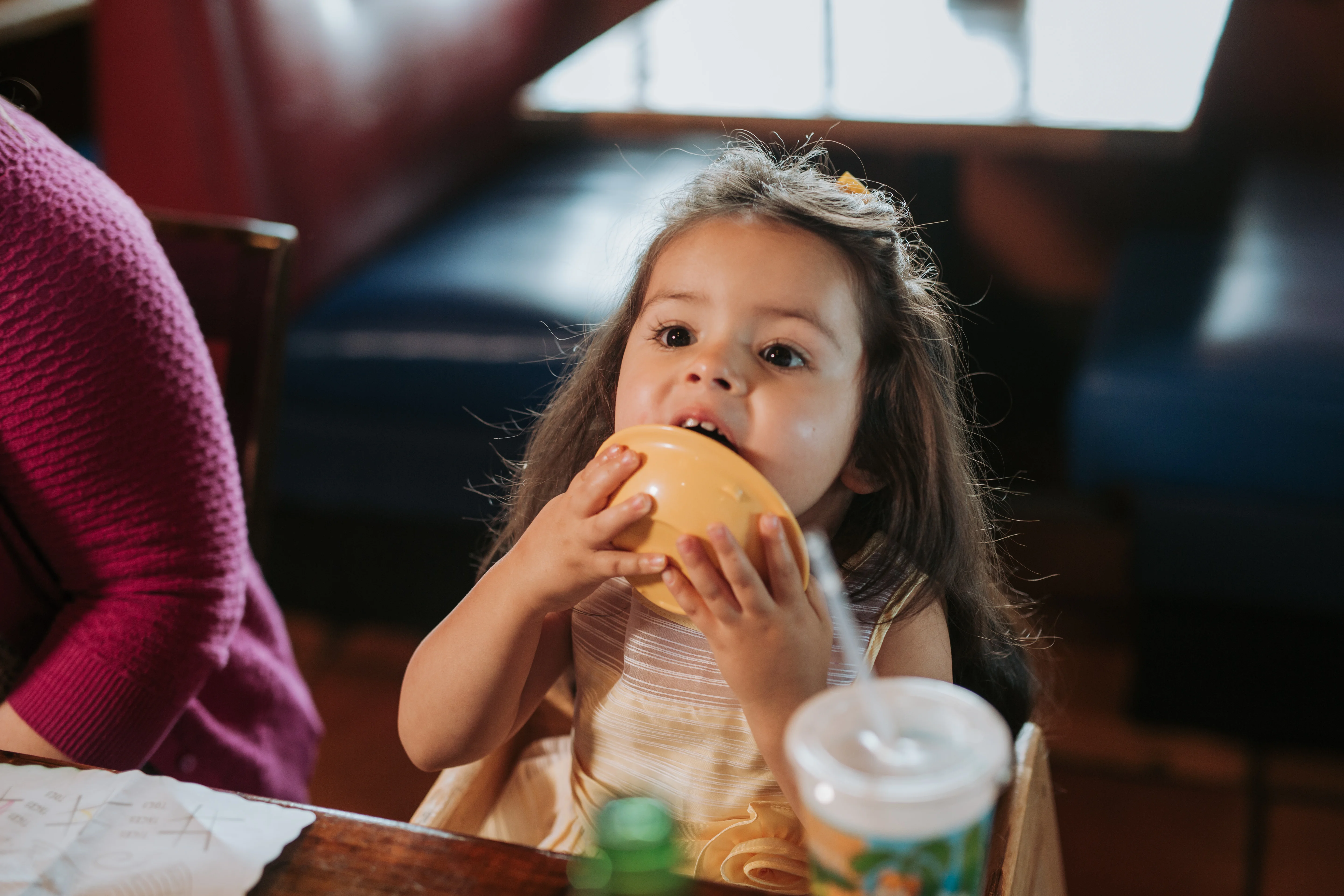 Child enjoying a colorful bowl in a cozy restaurant setting