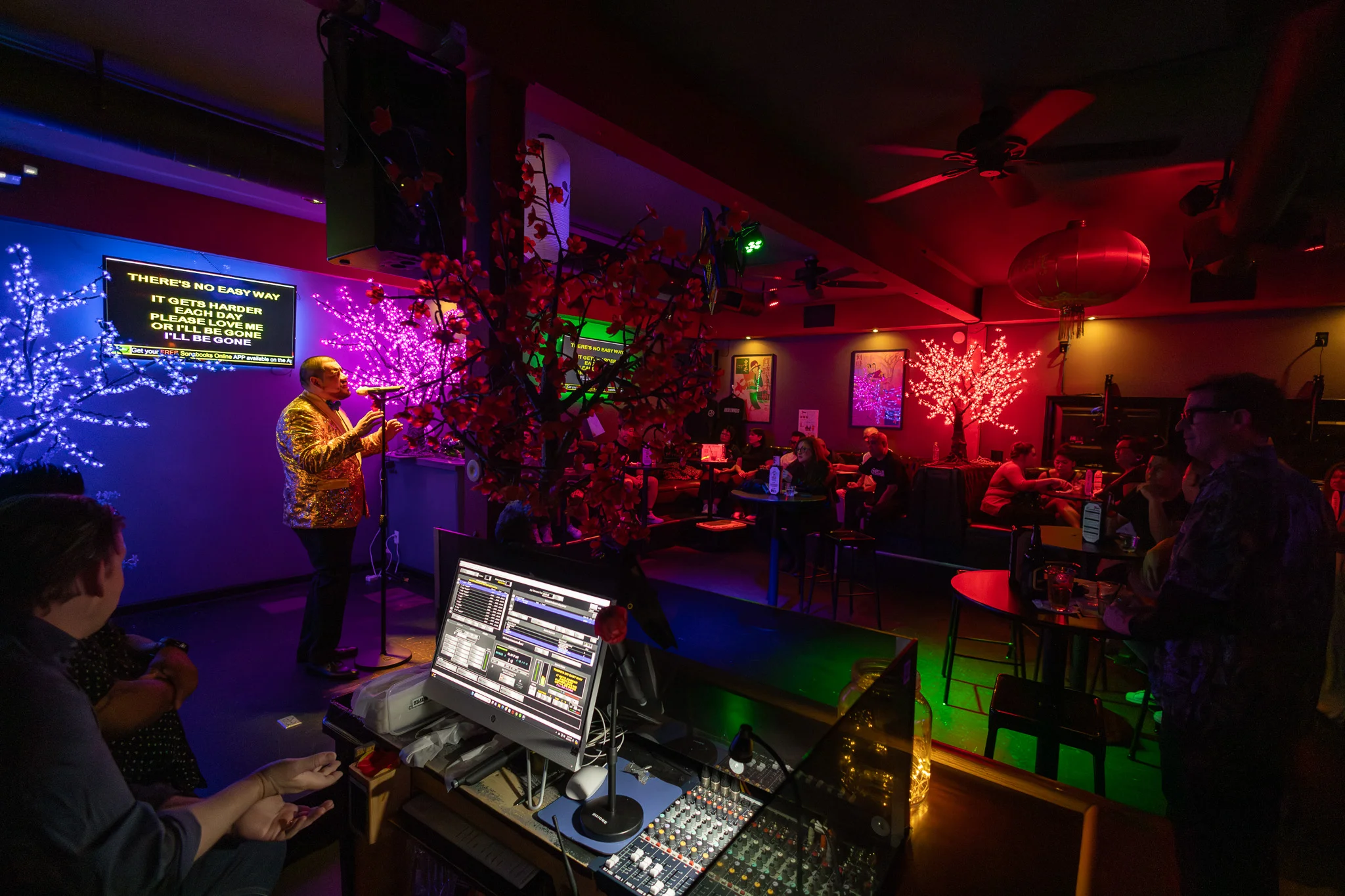 Vibrant karaoke night in a lively restaurant with colorful lighting