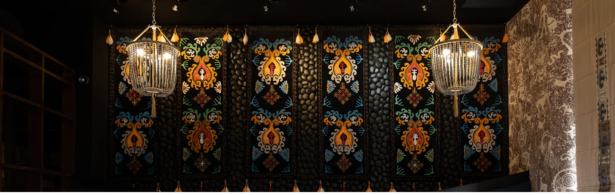 Elegant restaurant interior with colorful wall decor and chandeliers