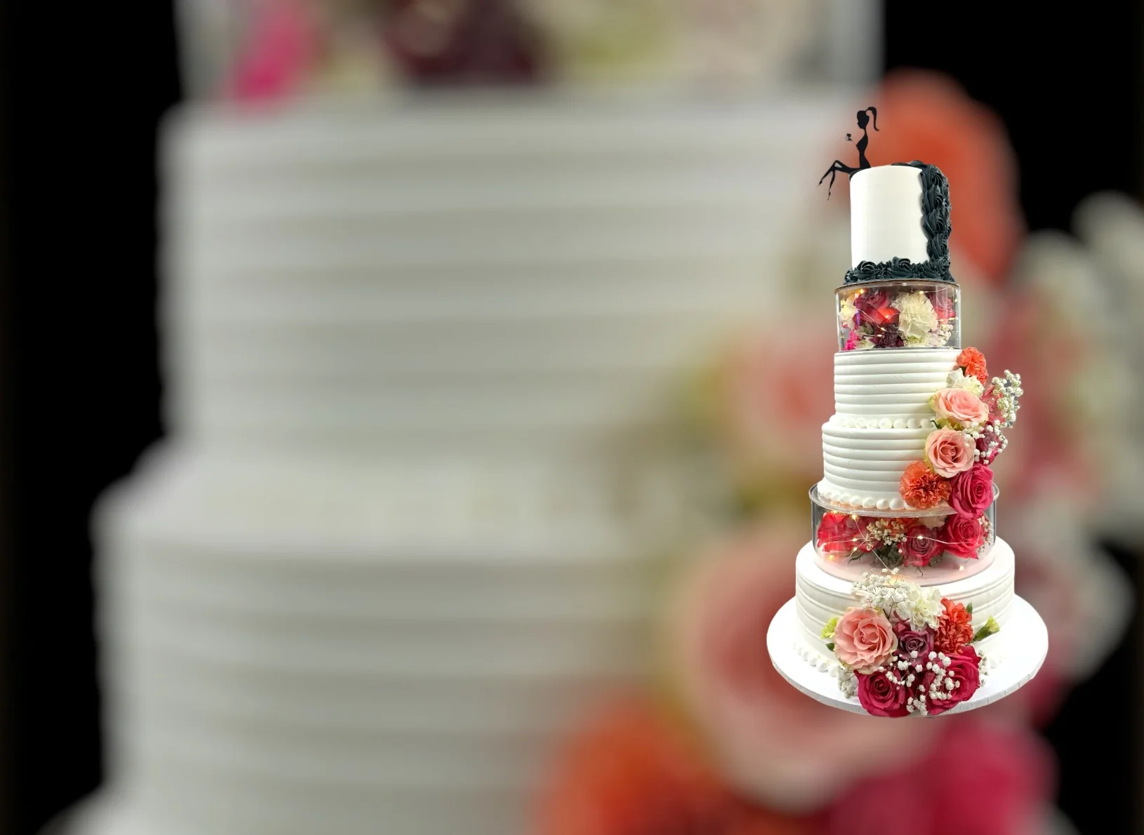 Elegant wedding cake adorned with flowers and a couple figurine