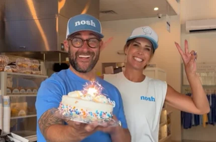 nosh NY bagels owners celebrating the Hilton Head Island grand opening with a cake.
