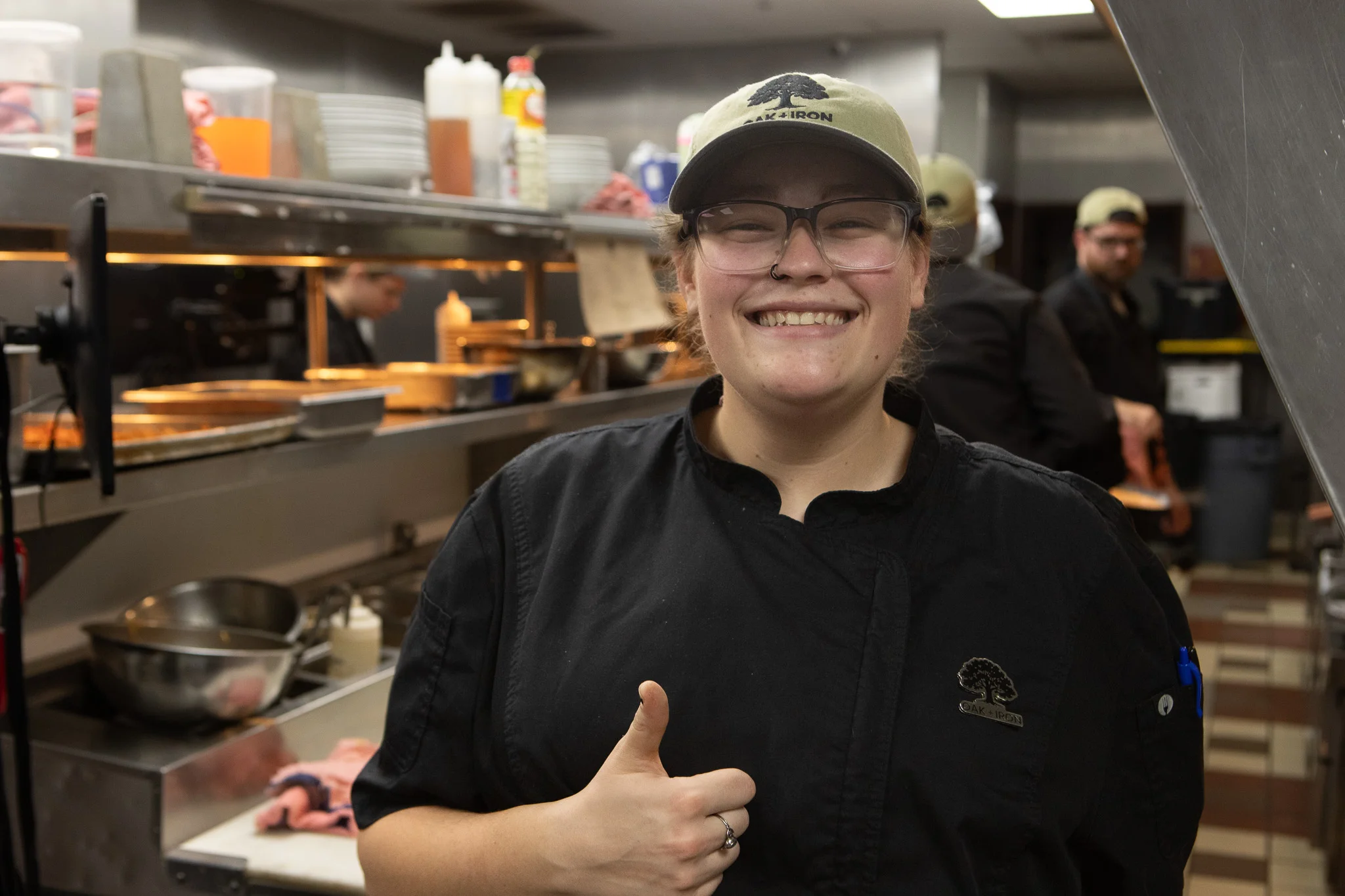 Chef smiling in a busy restaurant kitchen