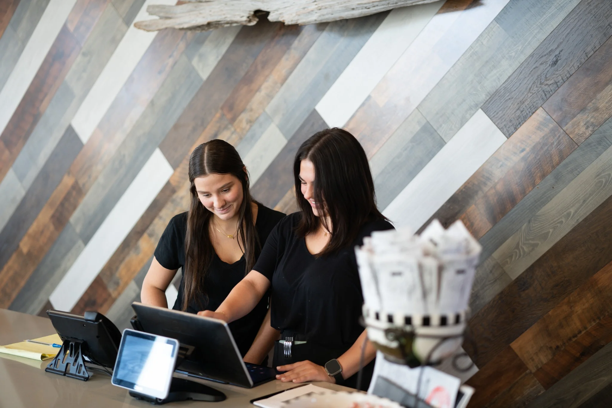 Two restaurant staff members at a modern counter